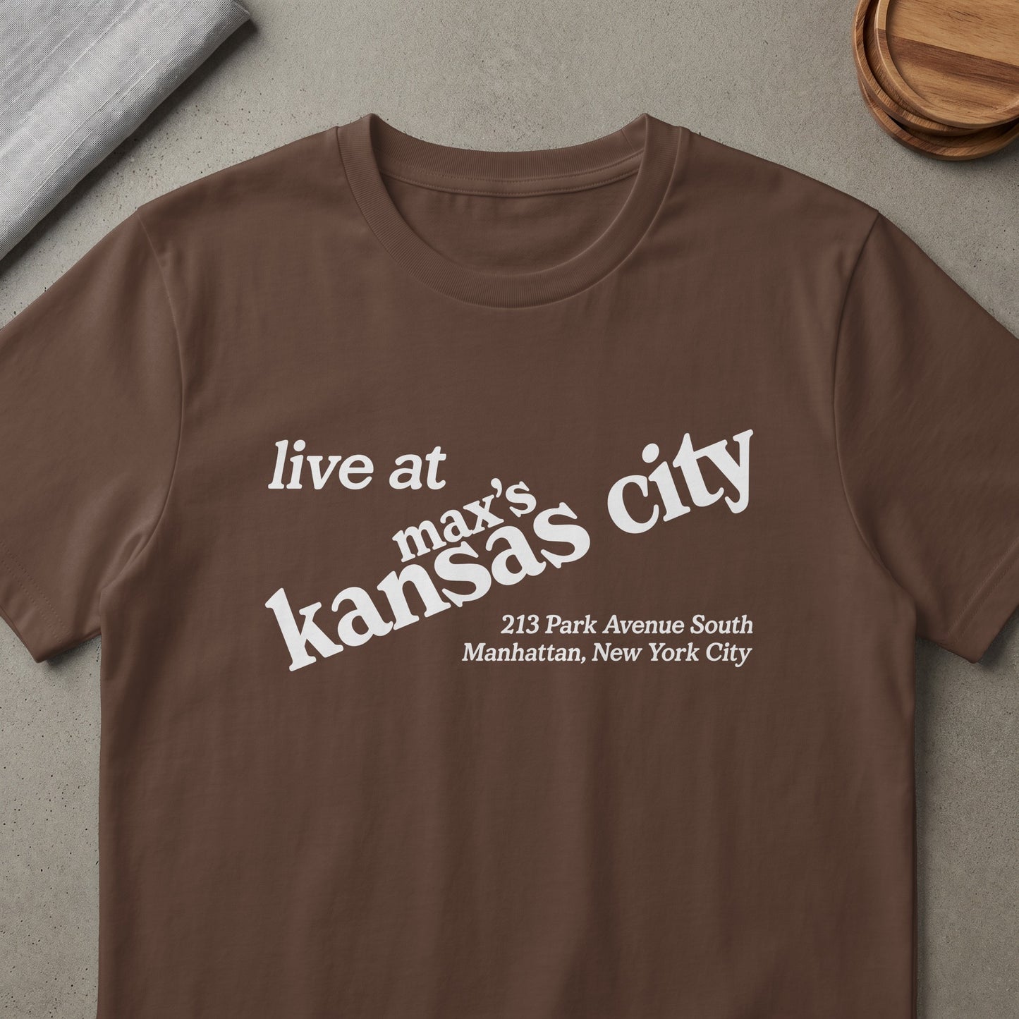 Brown t-shirt with white text "live at max's kansas city" and address.