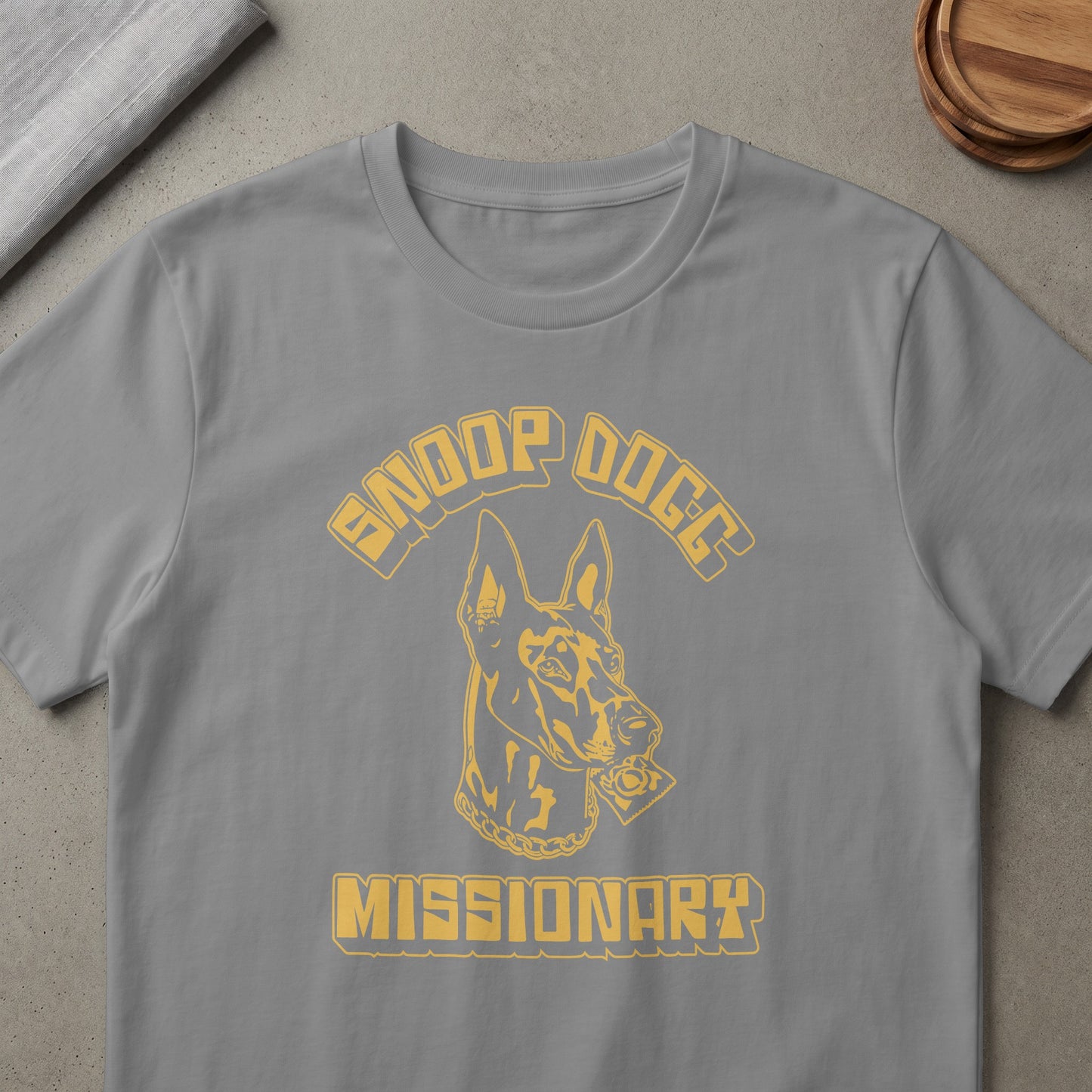 Grey t-shirt with yellow "Snoop Dogg" text, a dog head, and "Missionary" text.