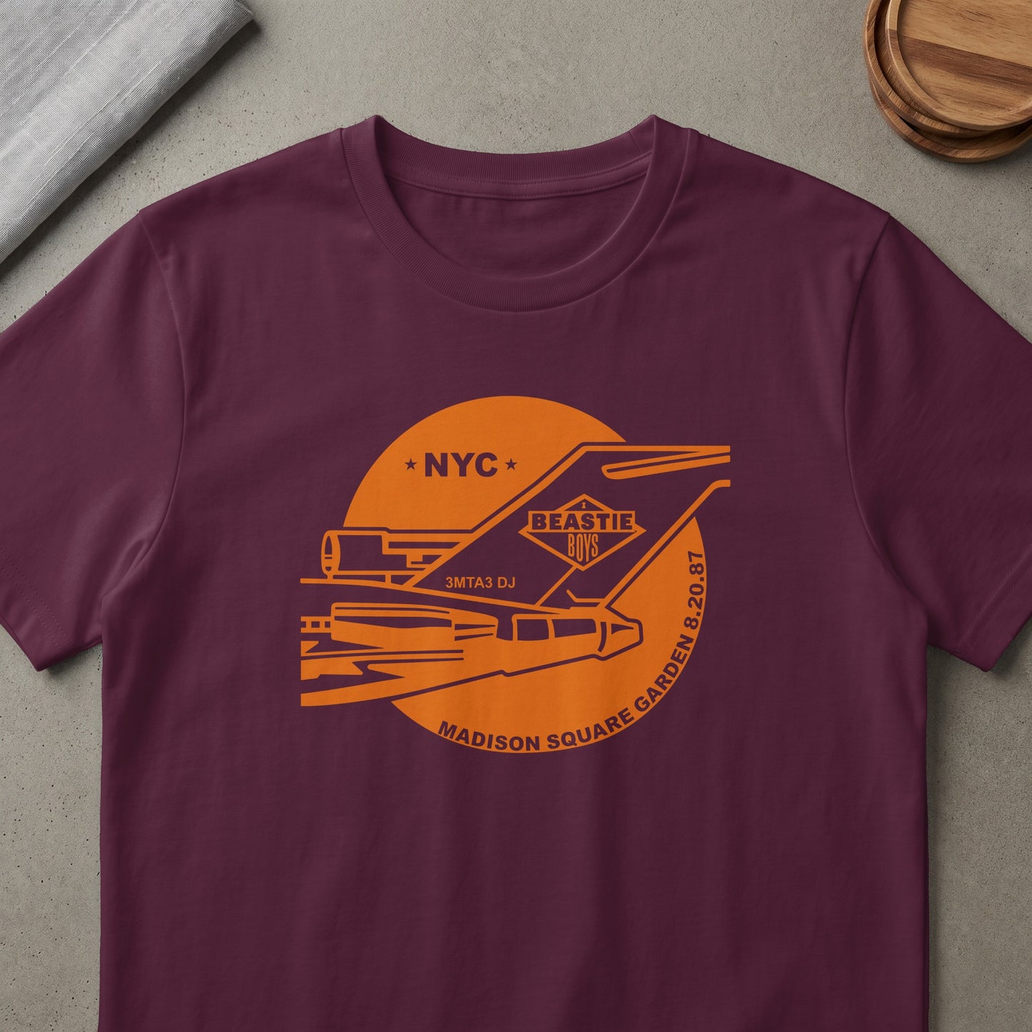 Maroon t-shirt with orange Beastie Boys Madison Square Garden 8.20.87 graphic.