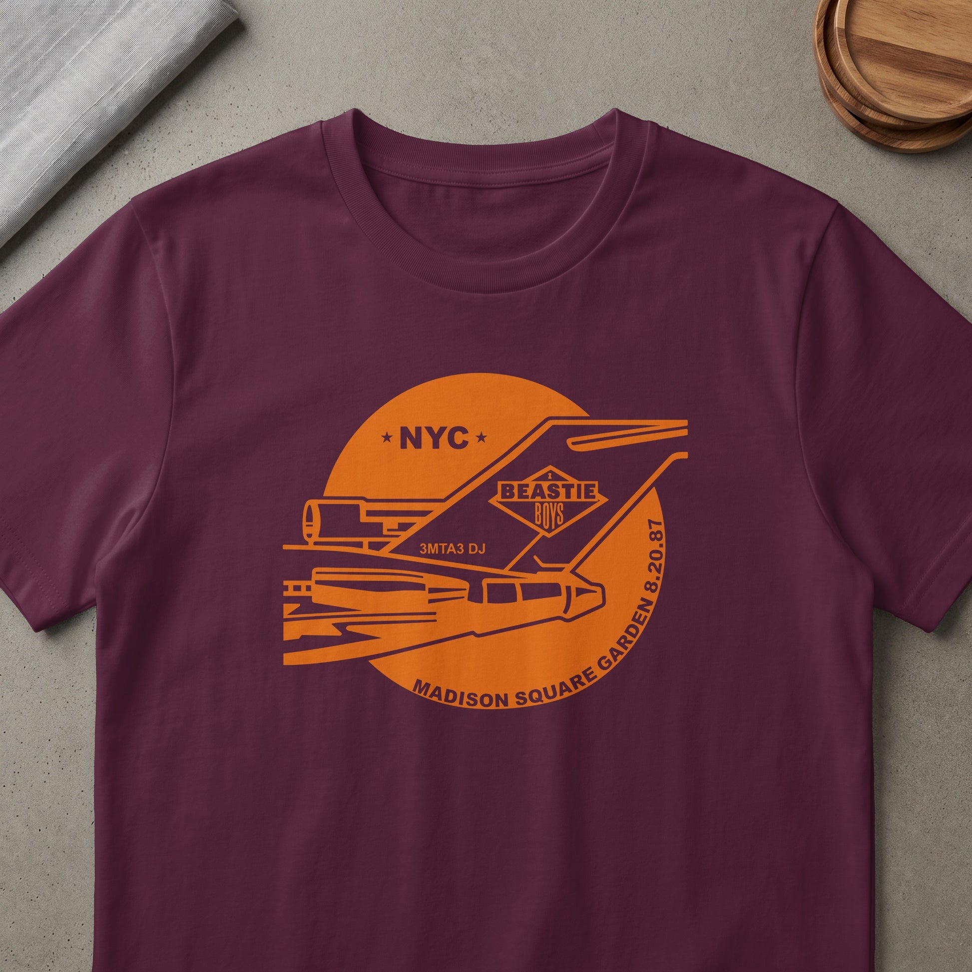 Maroon t-shirt with orange Beastie Boys Madison Square Garden 8.20.87 graphic.
