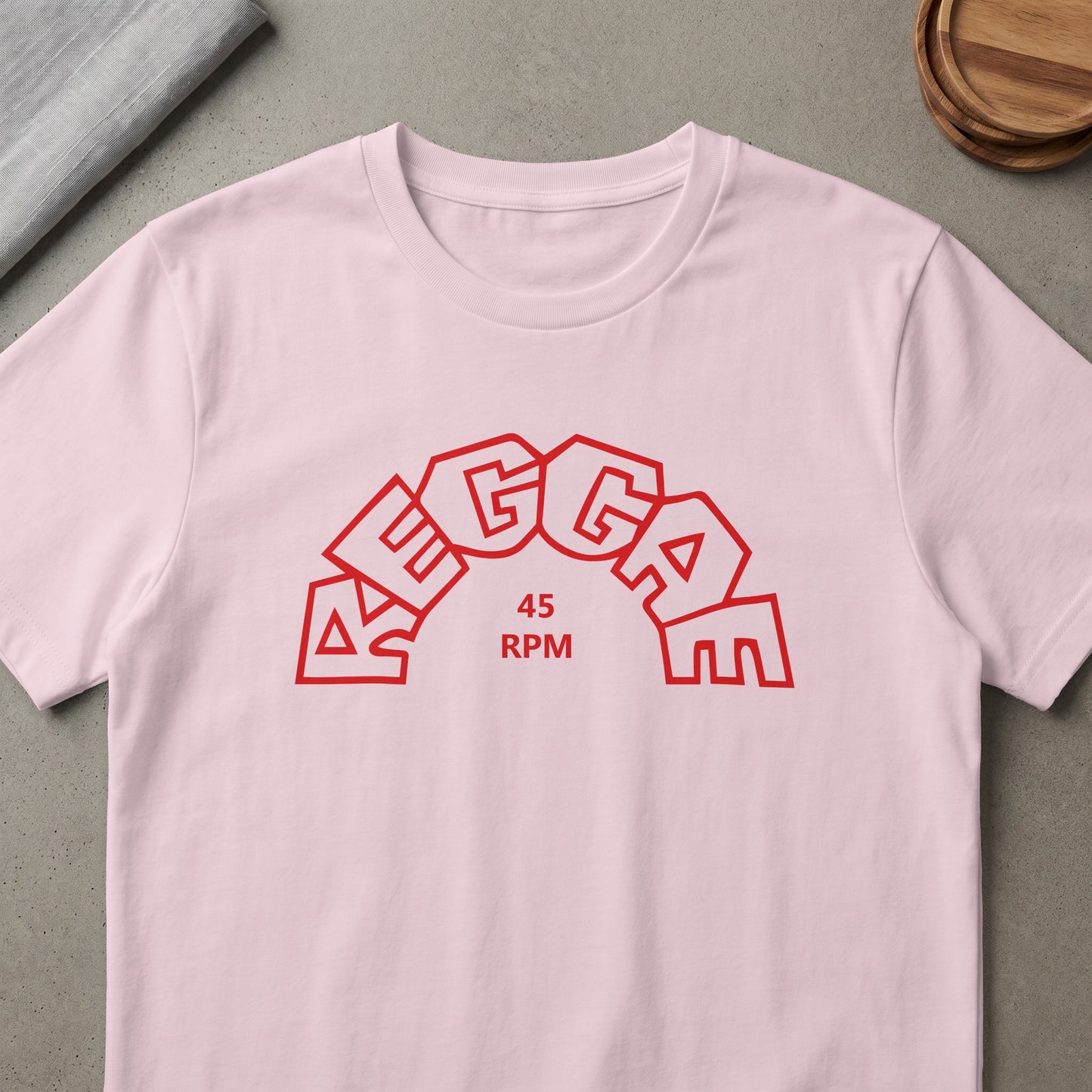 Pink t-shirt with red "REGGAE 45 RPM" text in a rainbow arch design.