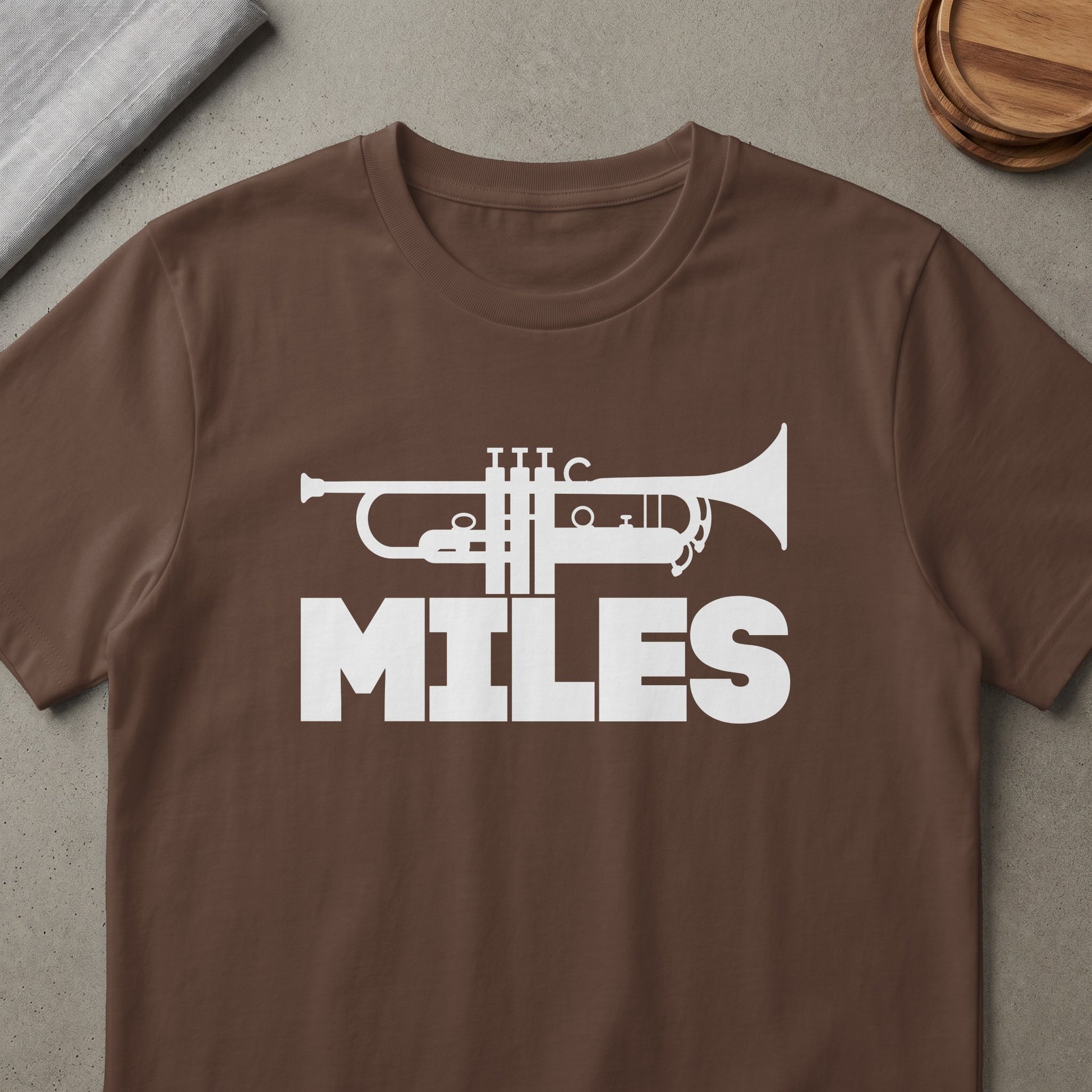 Brown t-shirt with white trumpet graphic and "MILES" text.