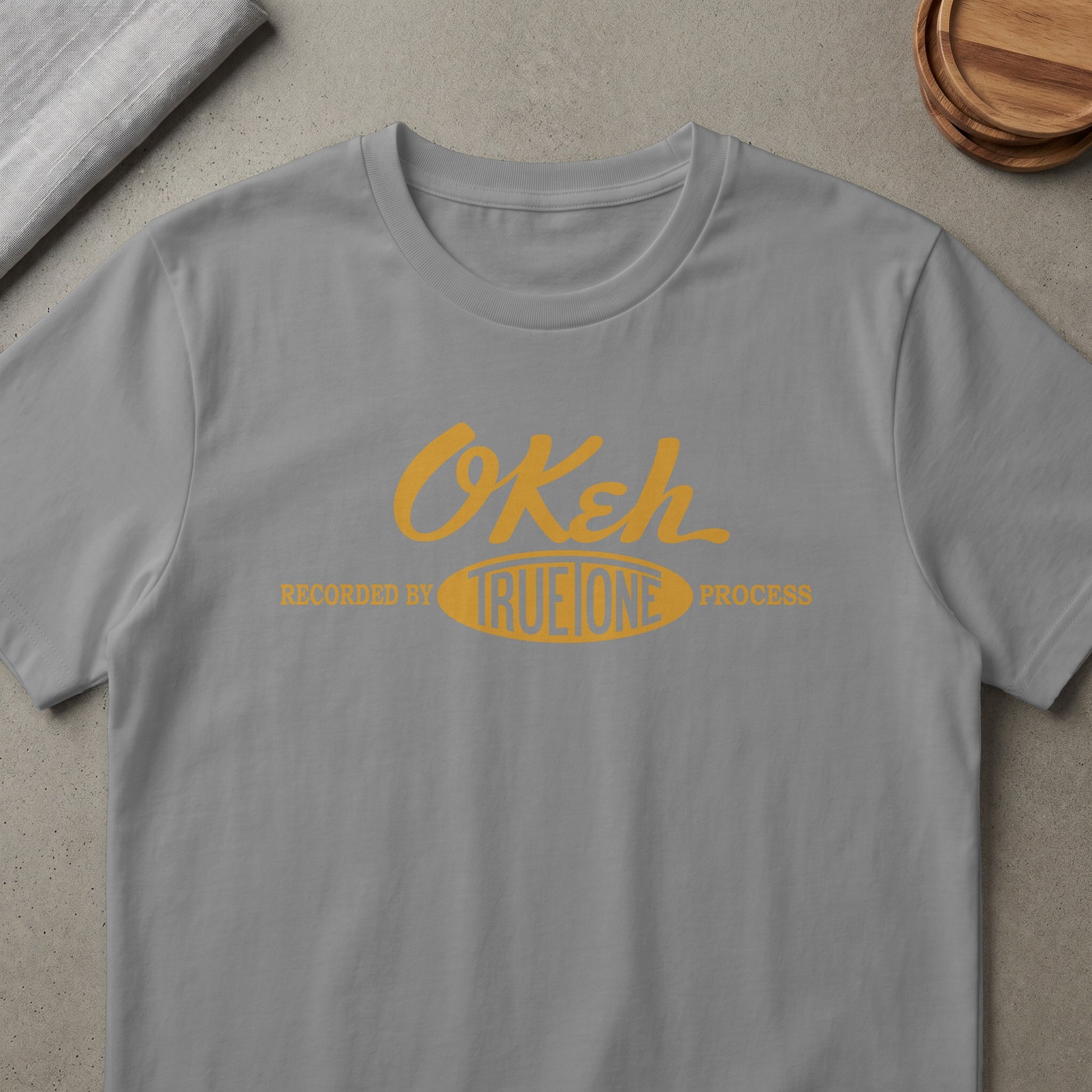 Grey t-shirt with yellow "OKeh" logo and text "RECORDED BY TRUEONE PROCESS"