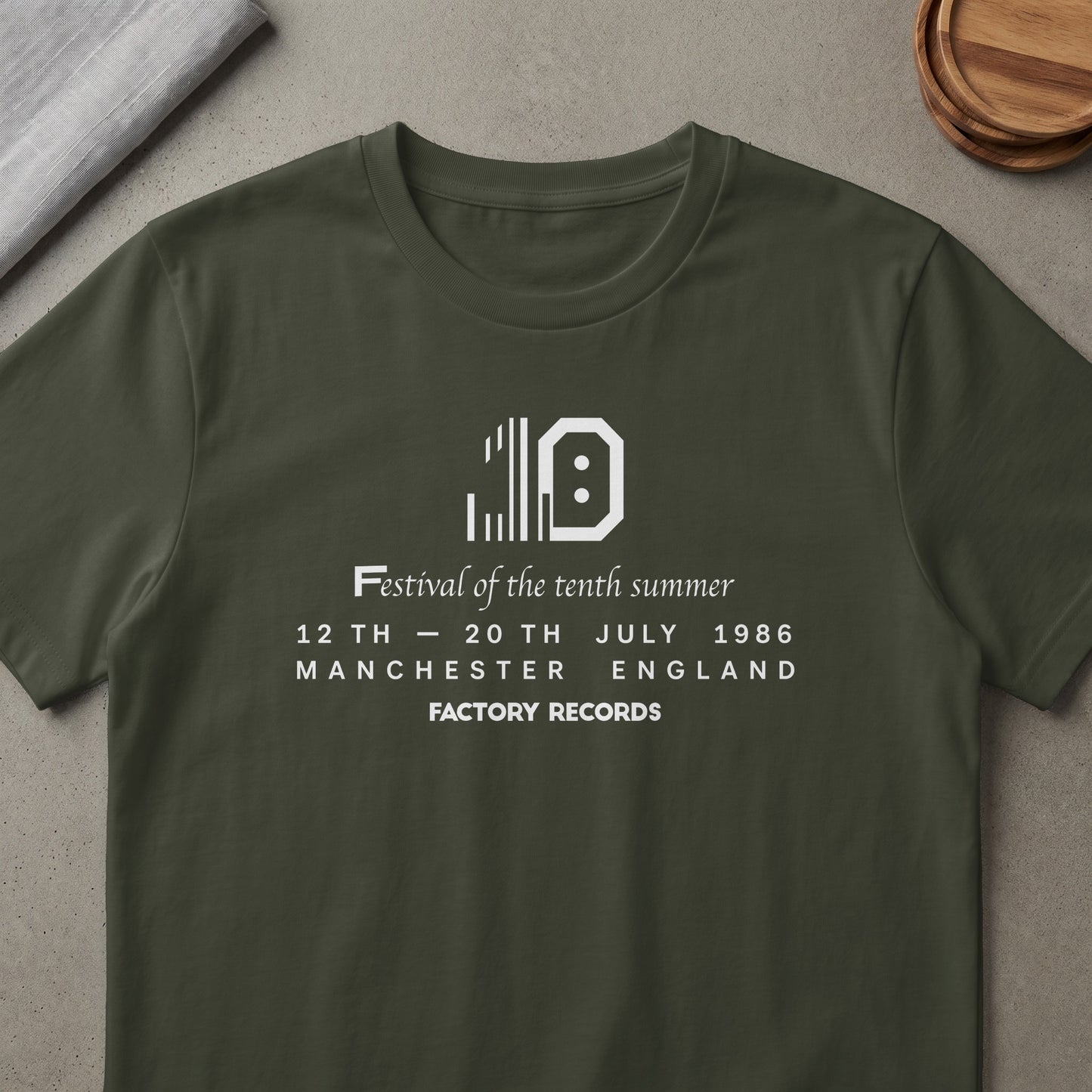 Dark green t-shirt with white "10" graphic, "Festival of the tenth summer," dates, and "FACTORY RECORDS" text.