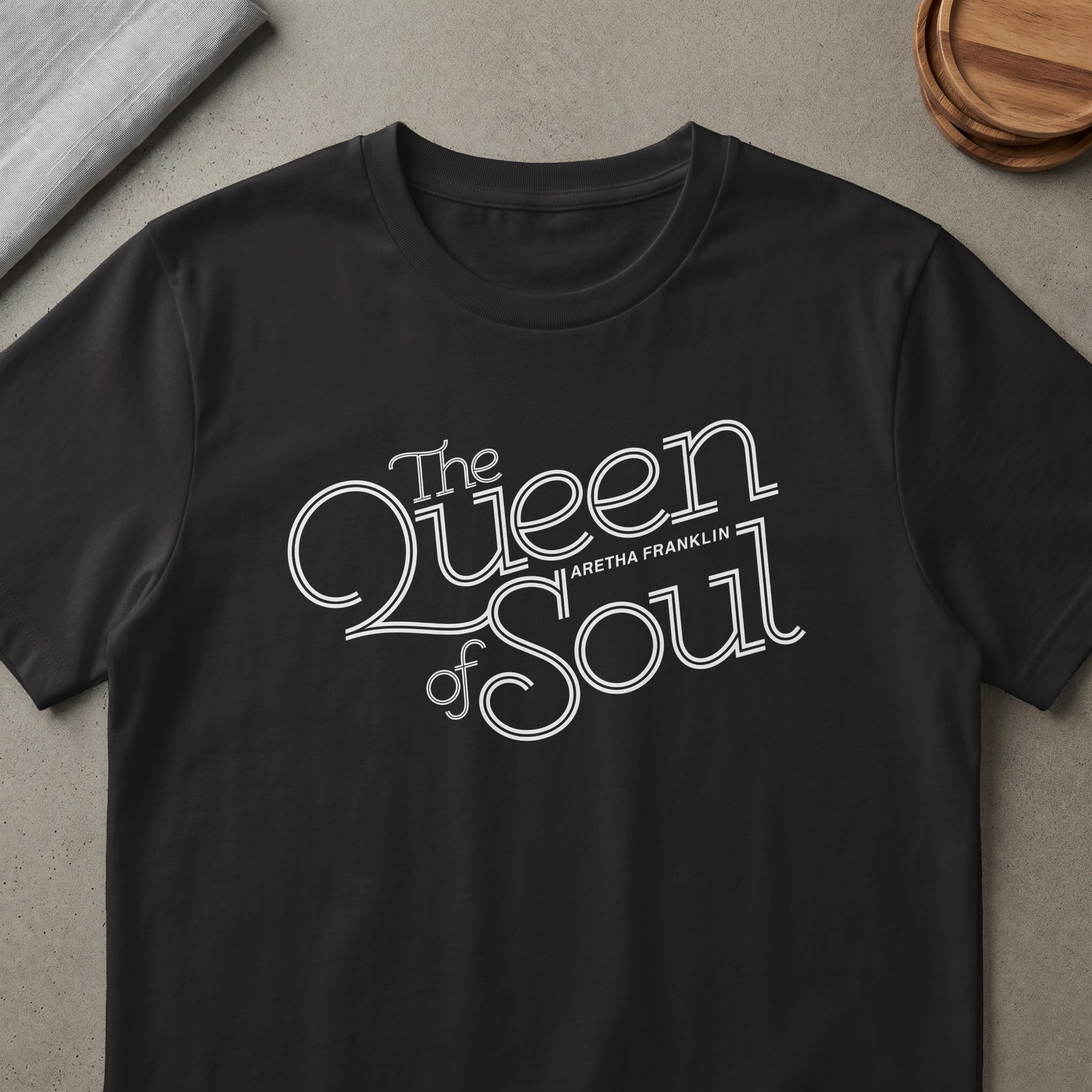 Black t-shirt with "The Queen of Soul Aretha Franklin" white text graphic.