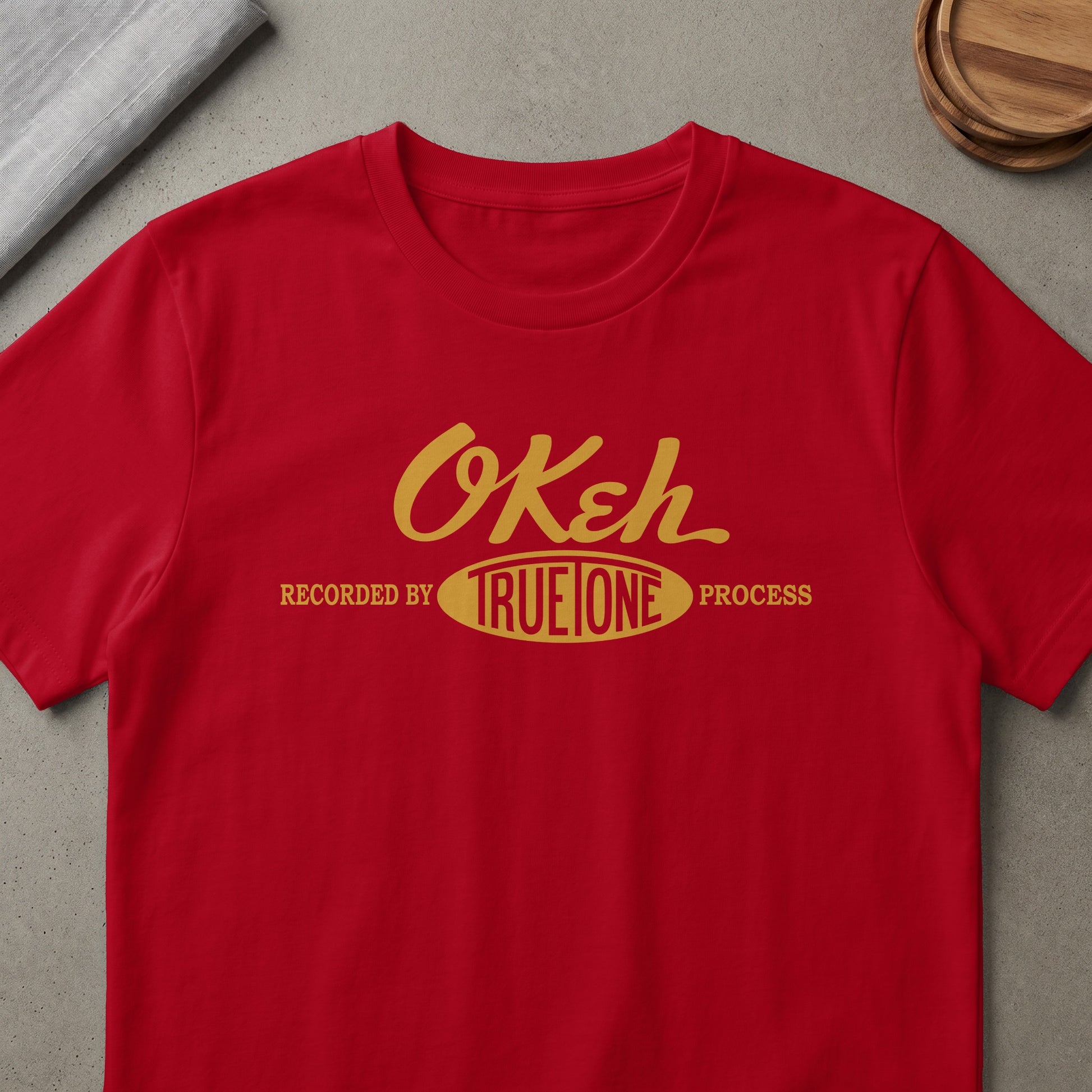 Red t-shirt with gold "Okeh" text and "Recorded by TrueTone Process" below.