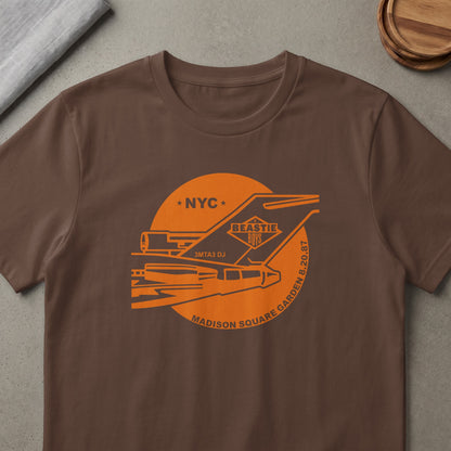 Brown t-shirt with orange Beastie Boys graphic featuring a plane, NYC, and Madison Square Garden 8.20.87.