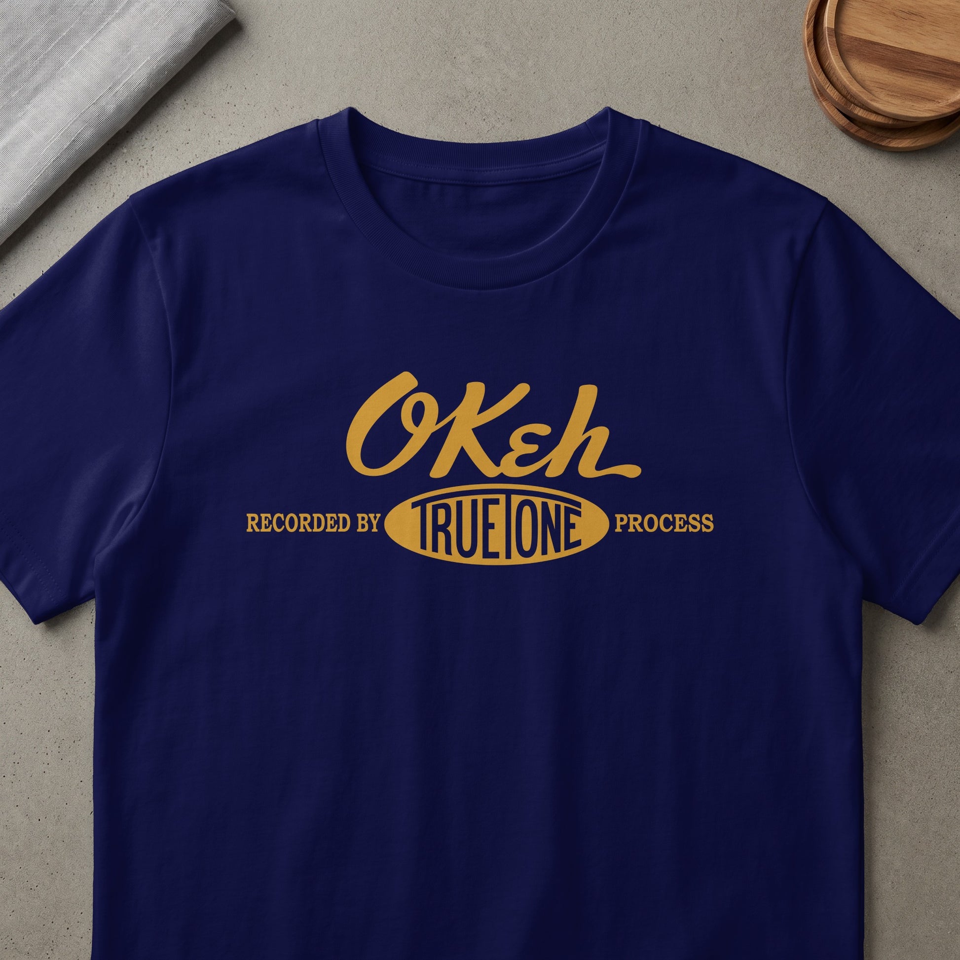 Navy t-shirt with gold "Okeh" logo and "Recorded by True Tone Process" text.