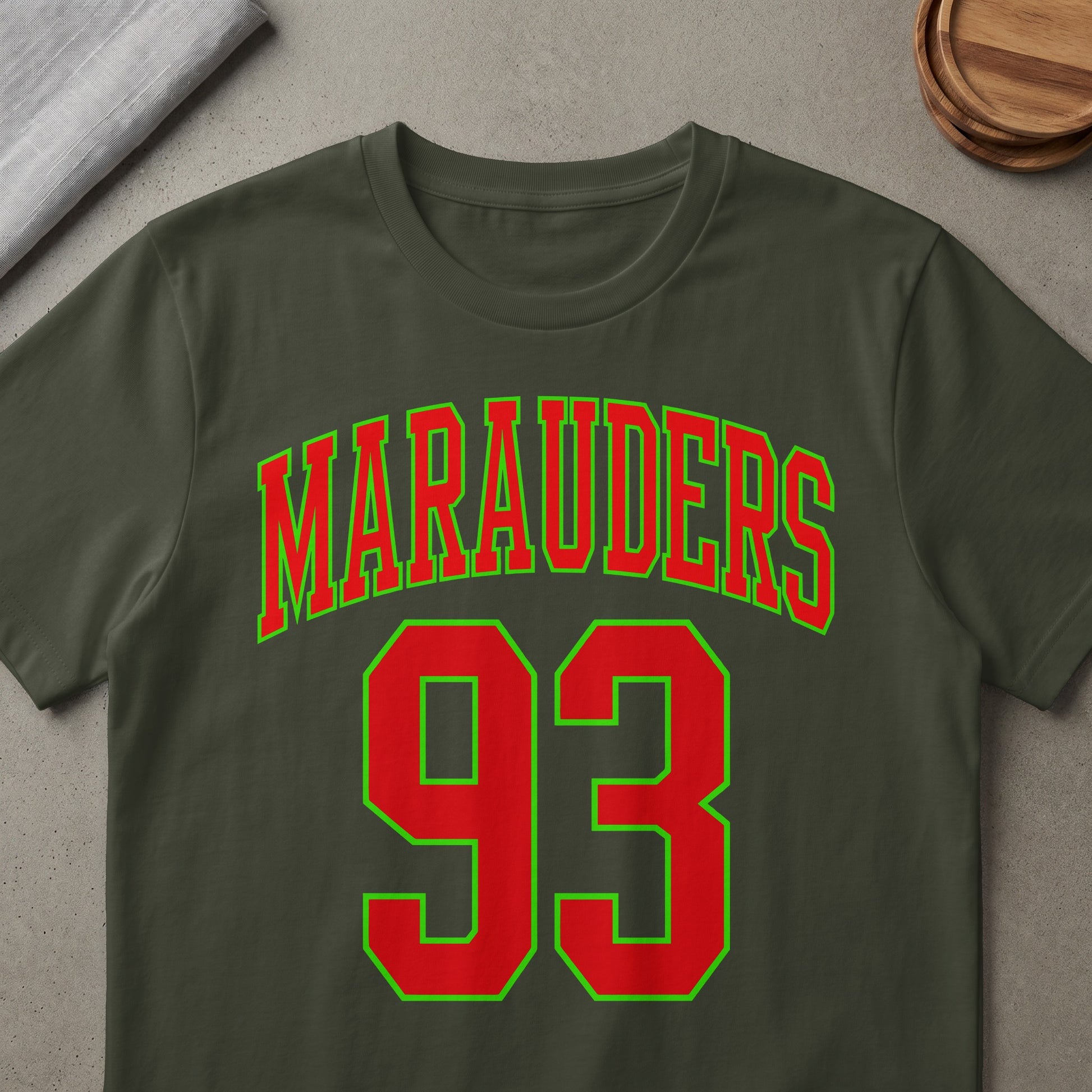 Green and red "Marauders 93" text on a dark olive green t-shirt.