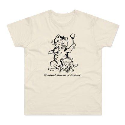 Cream t-shirt with a black, ink-style drawing of a cat playing a drum, with text.