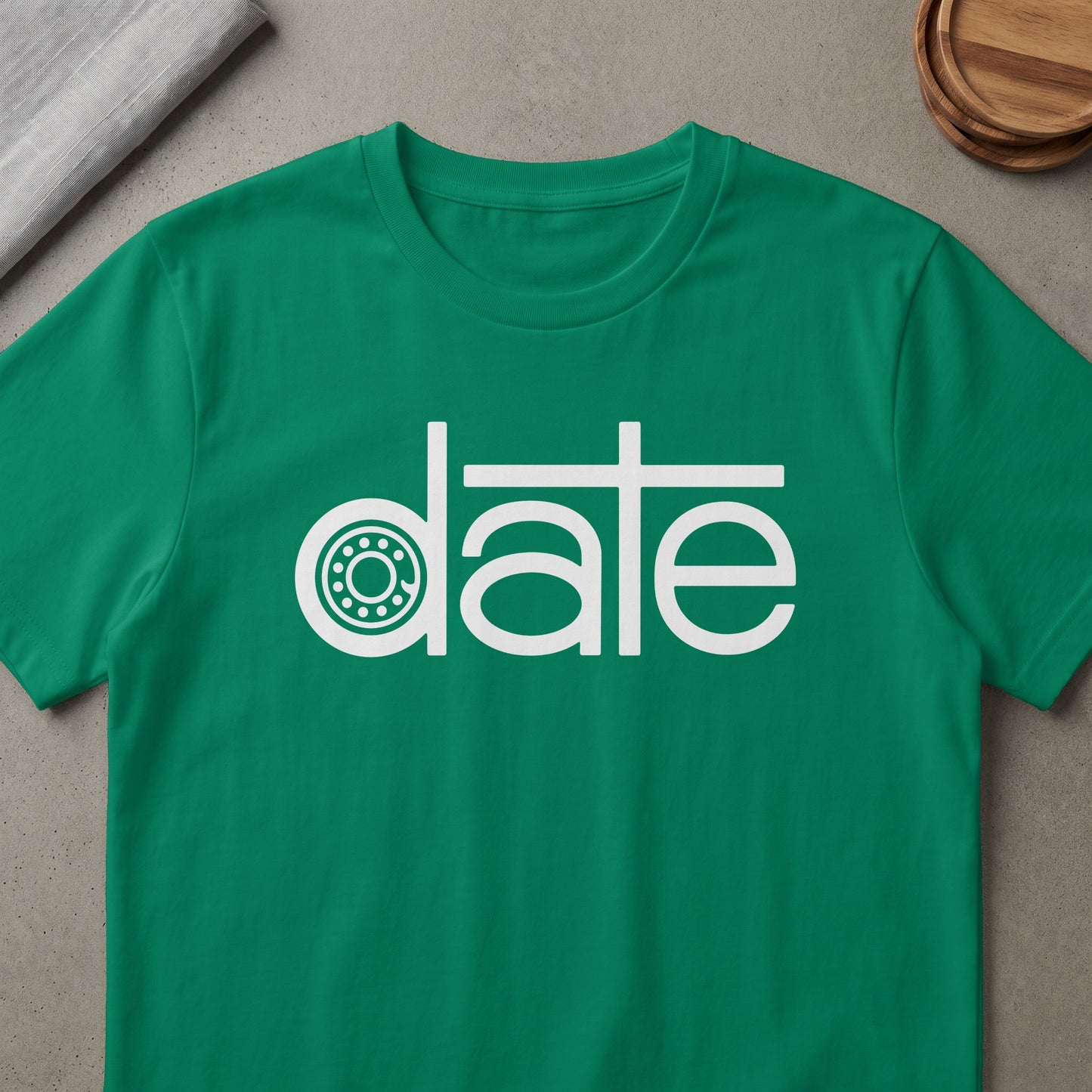 Green t-shirt with white text "date" and a bearing graphic as the "a".
