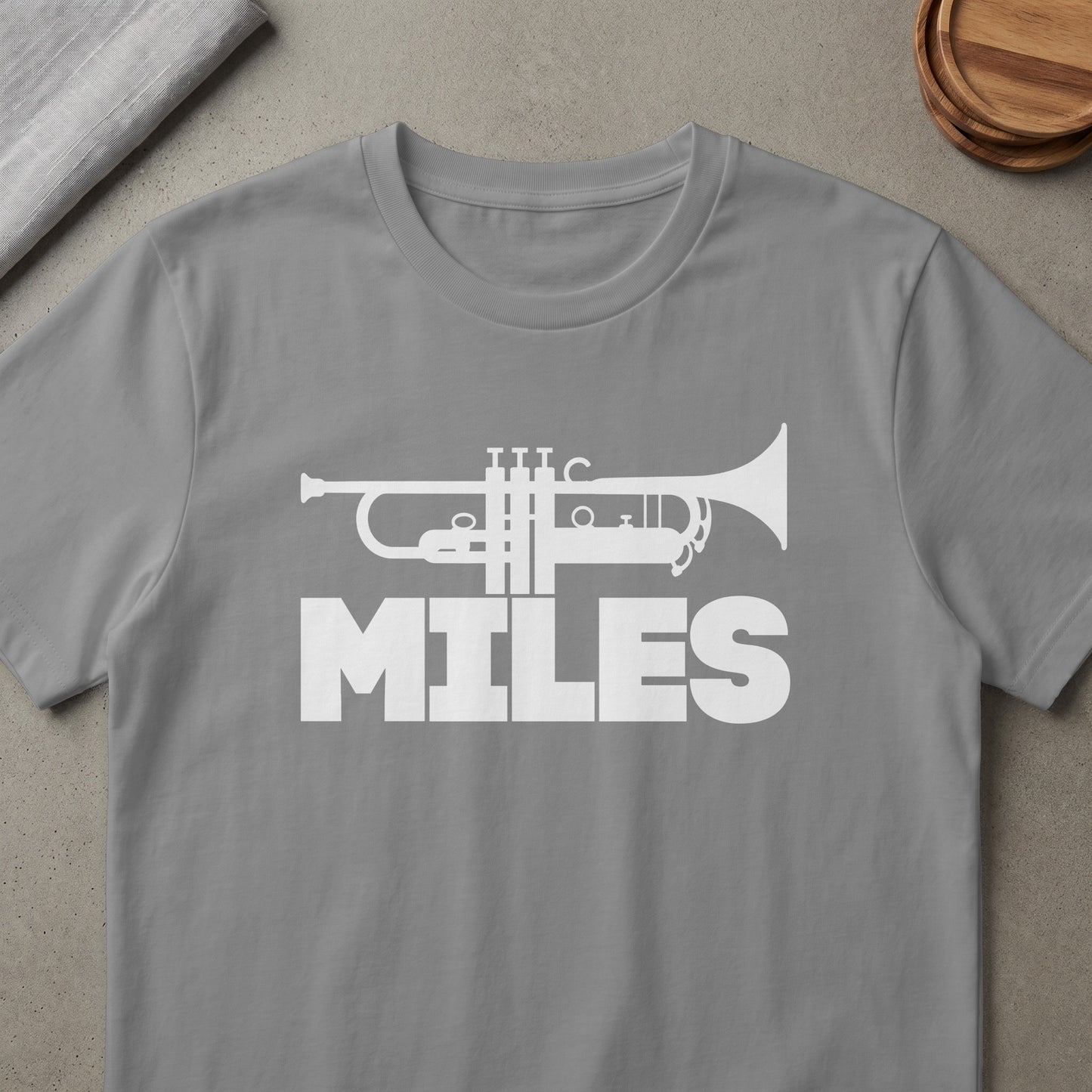 Grey t-shirt with white trumpet graphic and "MILES" text.