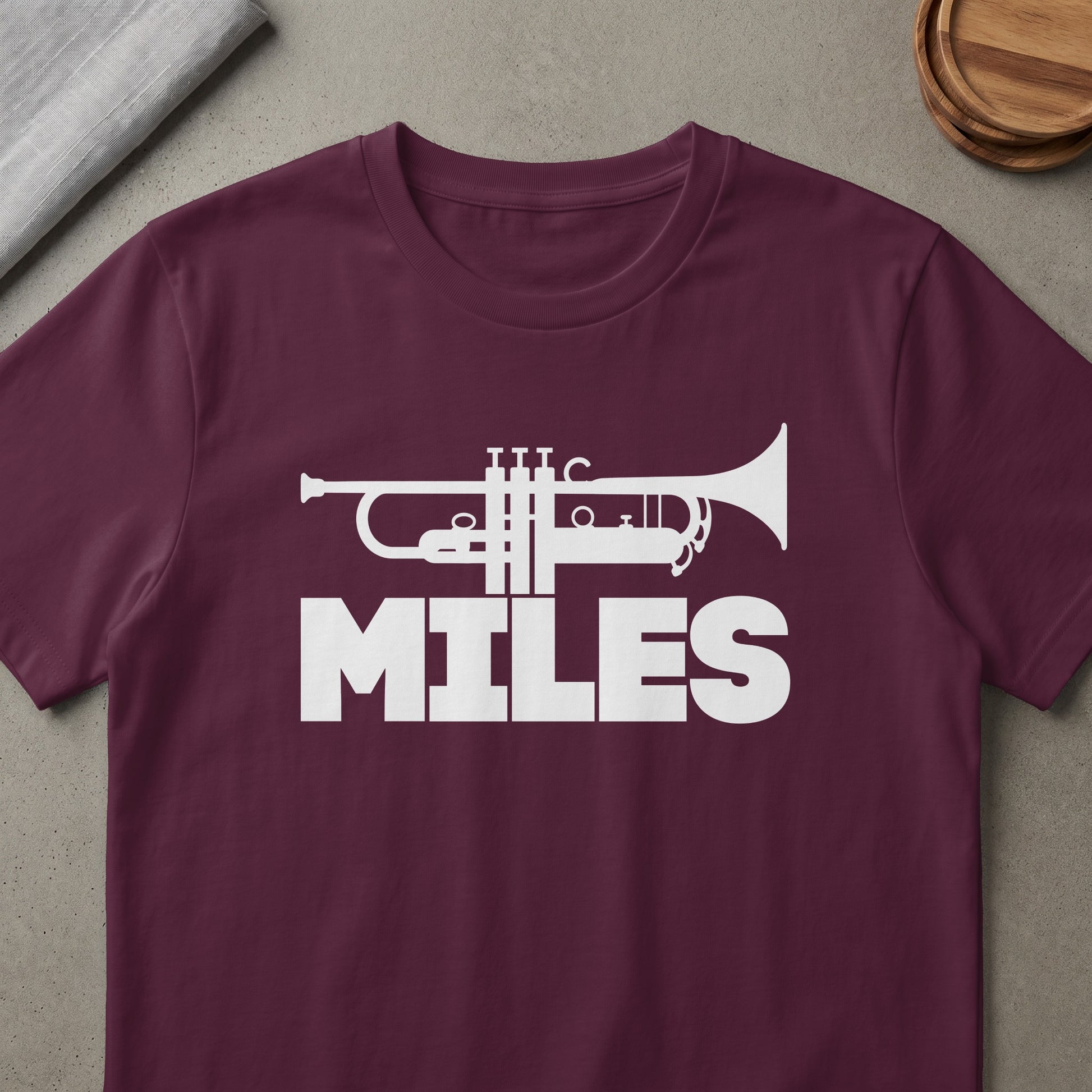 Maroon t-shirt with white trumpet graphic and "MILES" text.