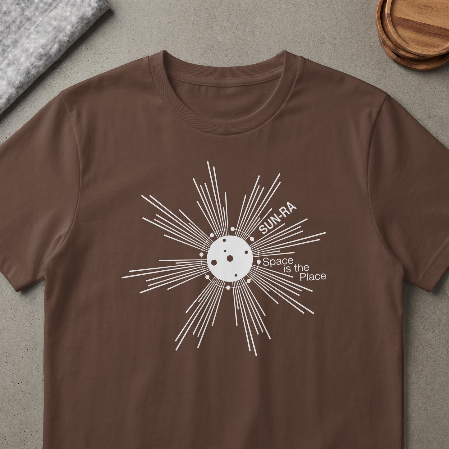Brown t-shirt with white Sun-Ra "Space is the Place" graphic.