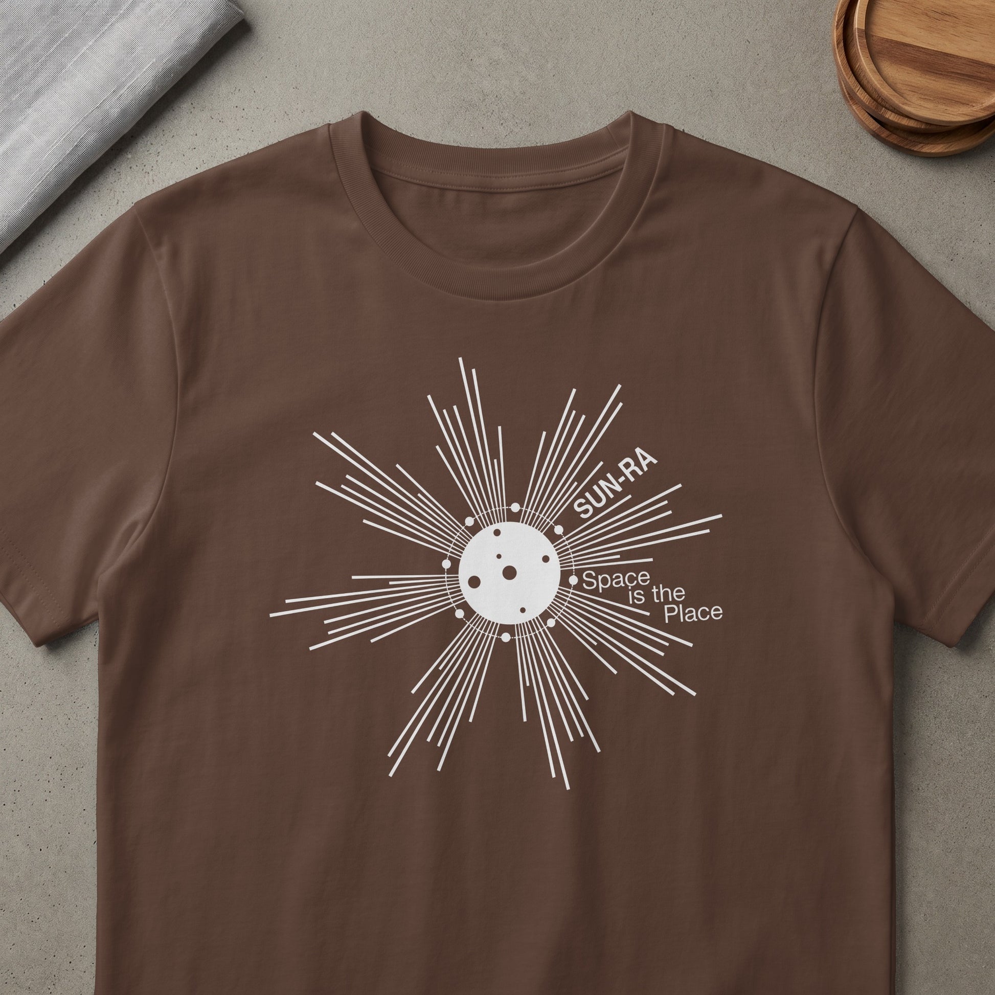 Brown t-shirt with white Sun-Ra "Space is the Place" graphic.
