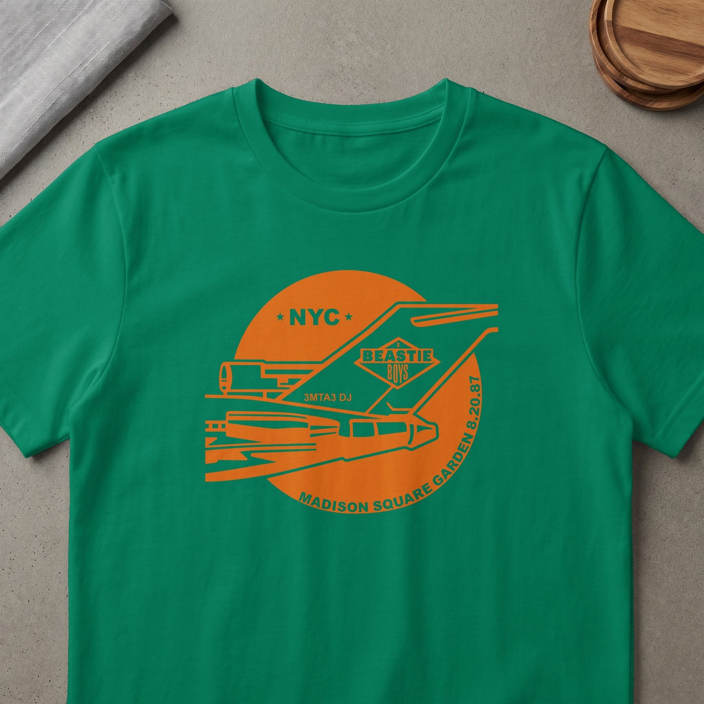 Green t-shirt with orange Beastie Boys graphic featuring NYC, 3MTA3 DJ, and Madison Square Garden 8.20.87.