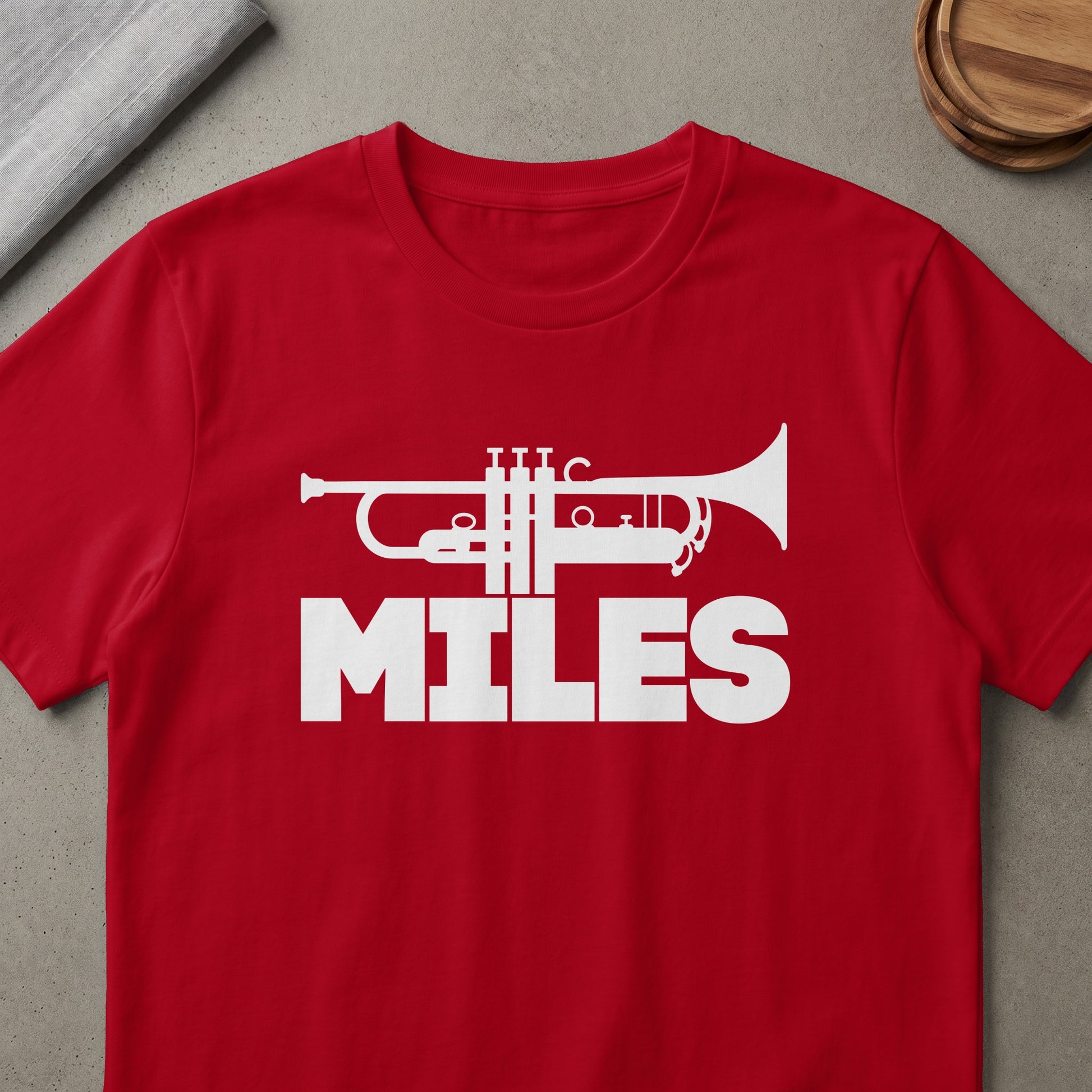 Red t-shirt with white trumpet graphic and the word MILES.