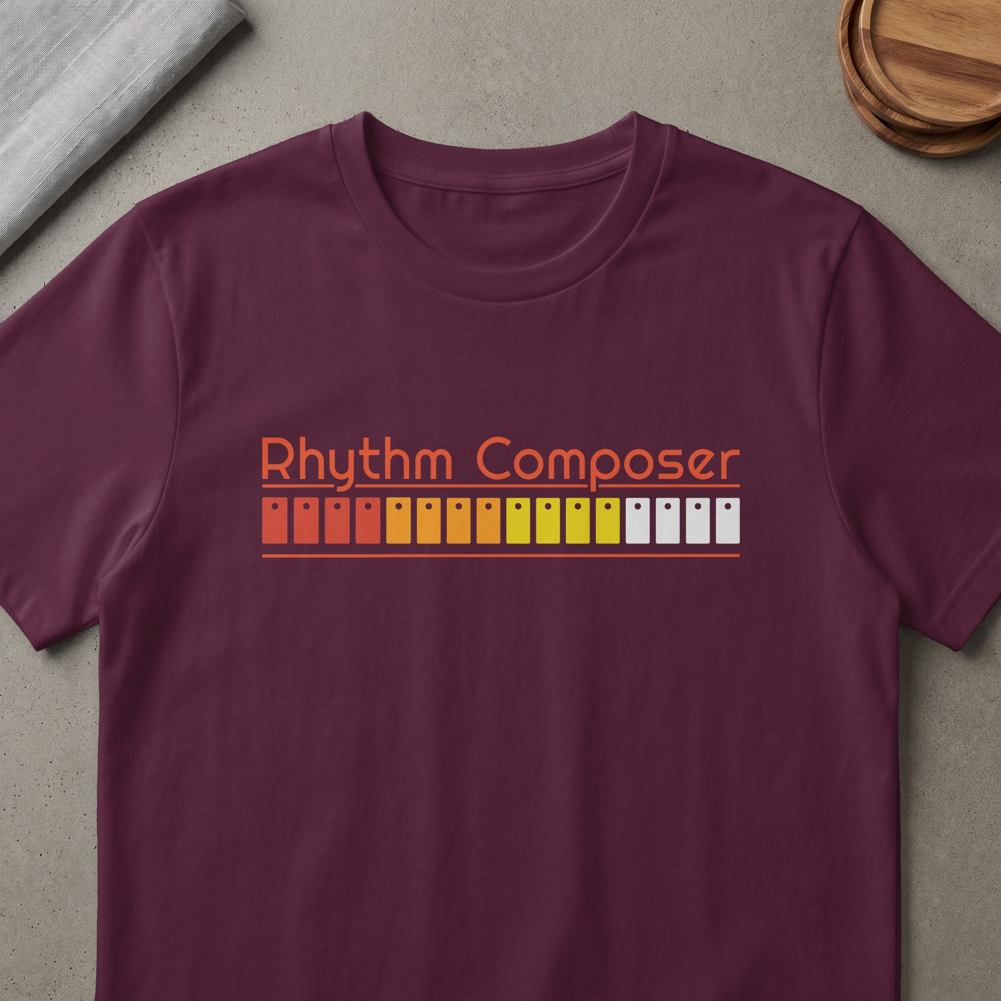 Maroon t-shirt with orange "Rhythm Composer" text and music producer buttons.