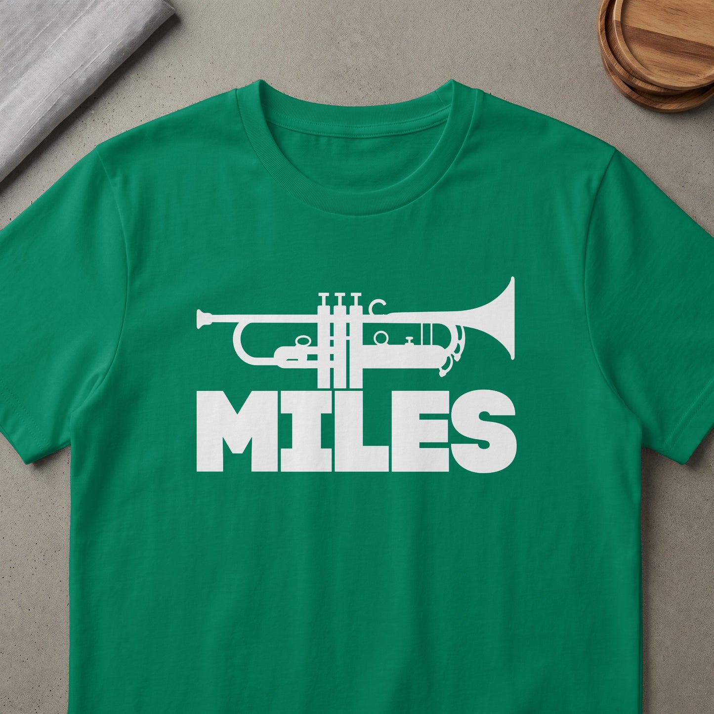 Green t-shirt with white trumpet graphic and the word "MILES"