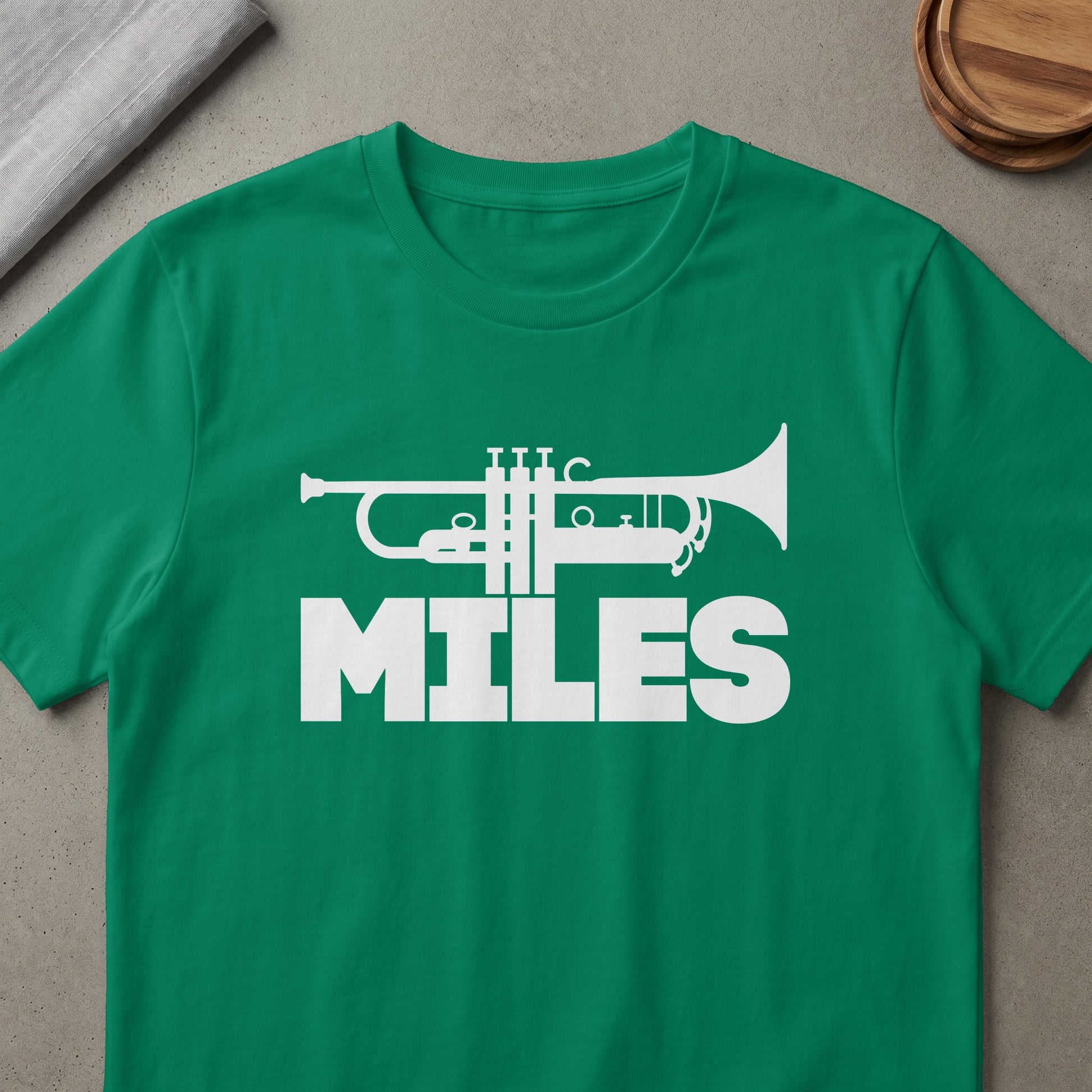Green t-shirt with white trumpet graphic and the word "MILES"