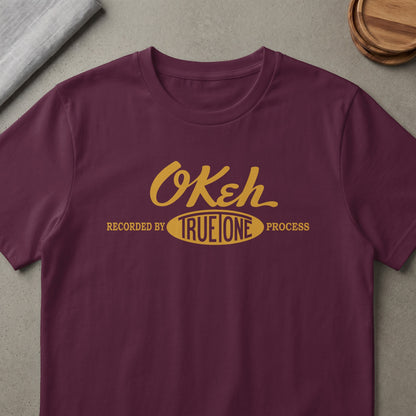 Maroon t-shirt with "OKeh TRUE ONE PROCESS" logo in yellow.