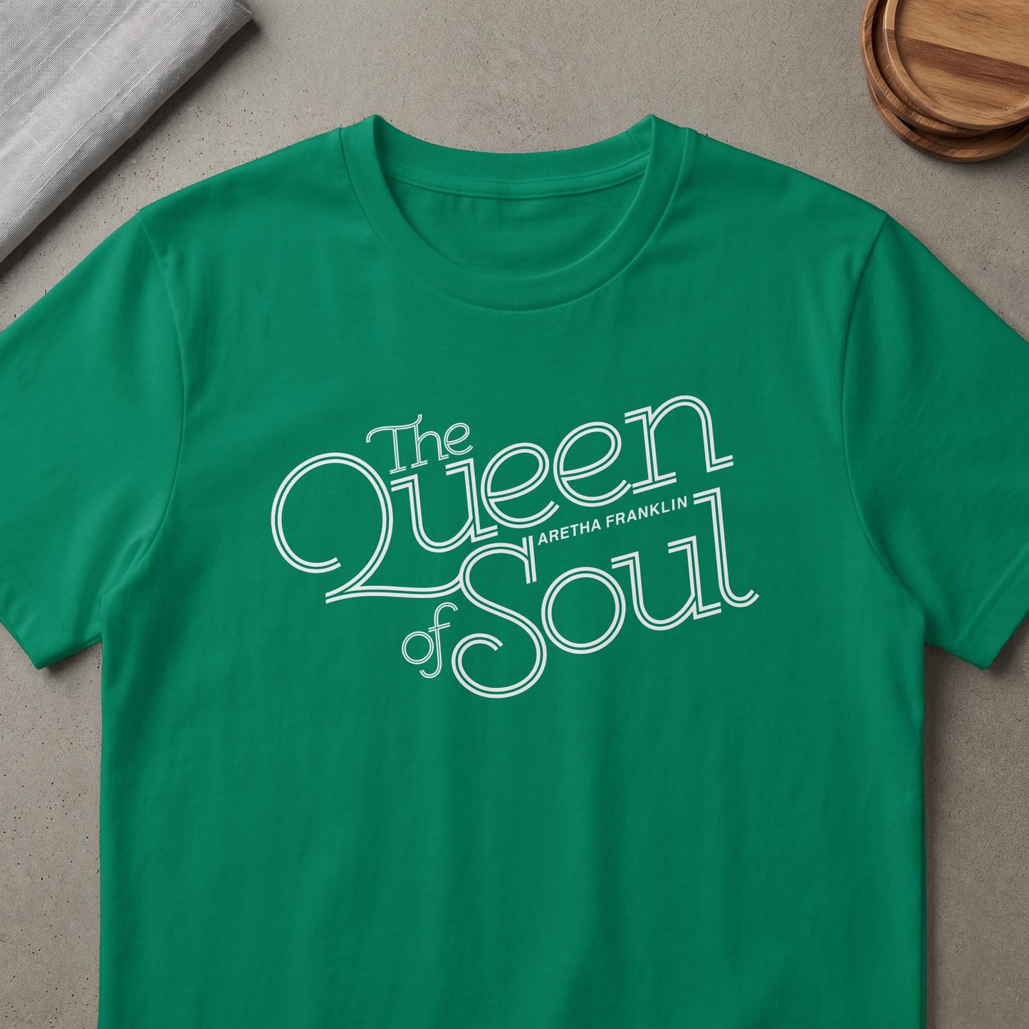 Green t-shirt with white "The Queen of Soul Aretha Franklin" text design.