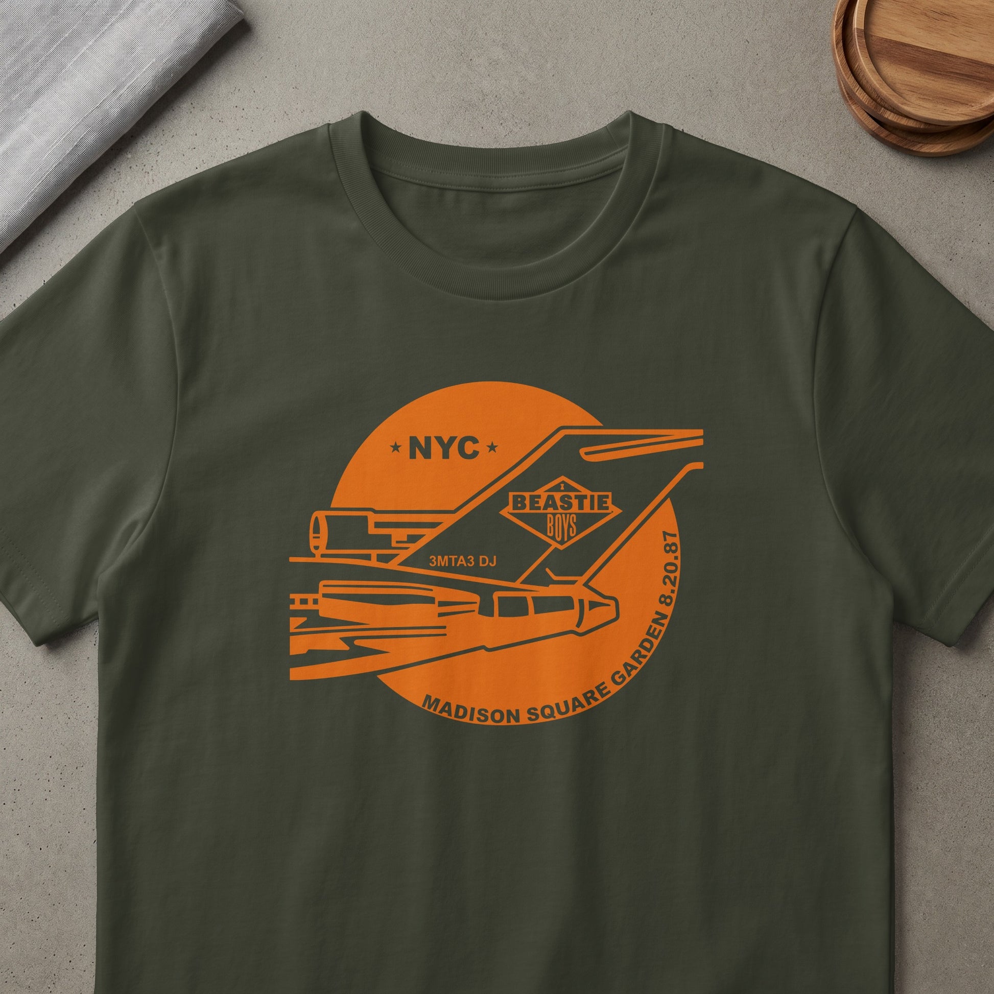 Beastie Boys NYC 3MTA3 DJ Madison Square Garden 8.20.87 graphic on dark green t-shirt.
