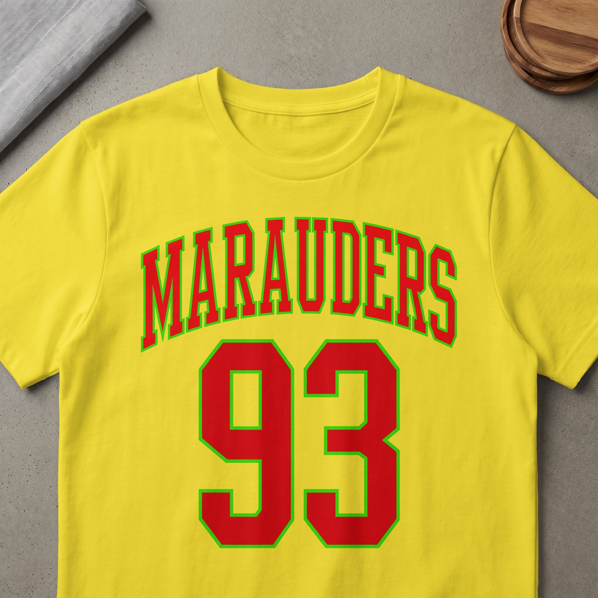 Yellow t-shirt with red and green "MARAUDERS 93" text