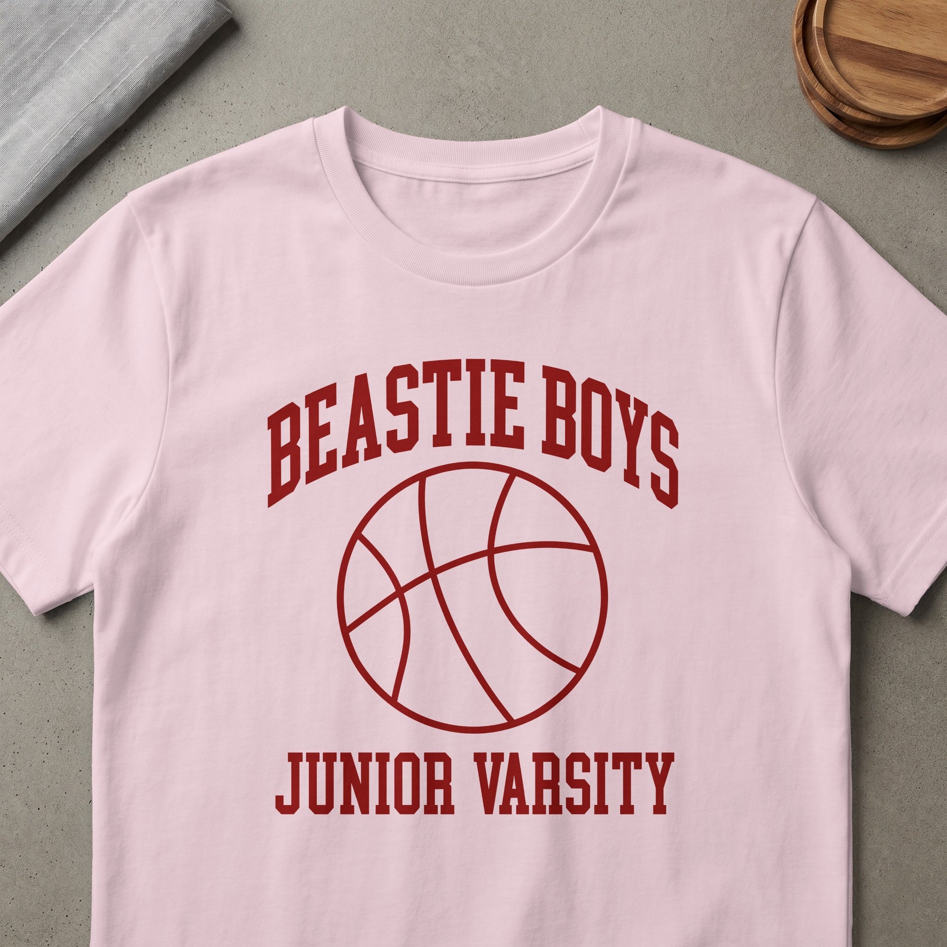 Pink t-shirt with maroon "Beastie Boys Junior Varsity" text and basketball graphic.