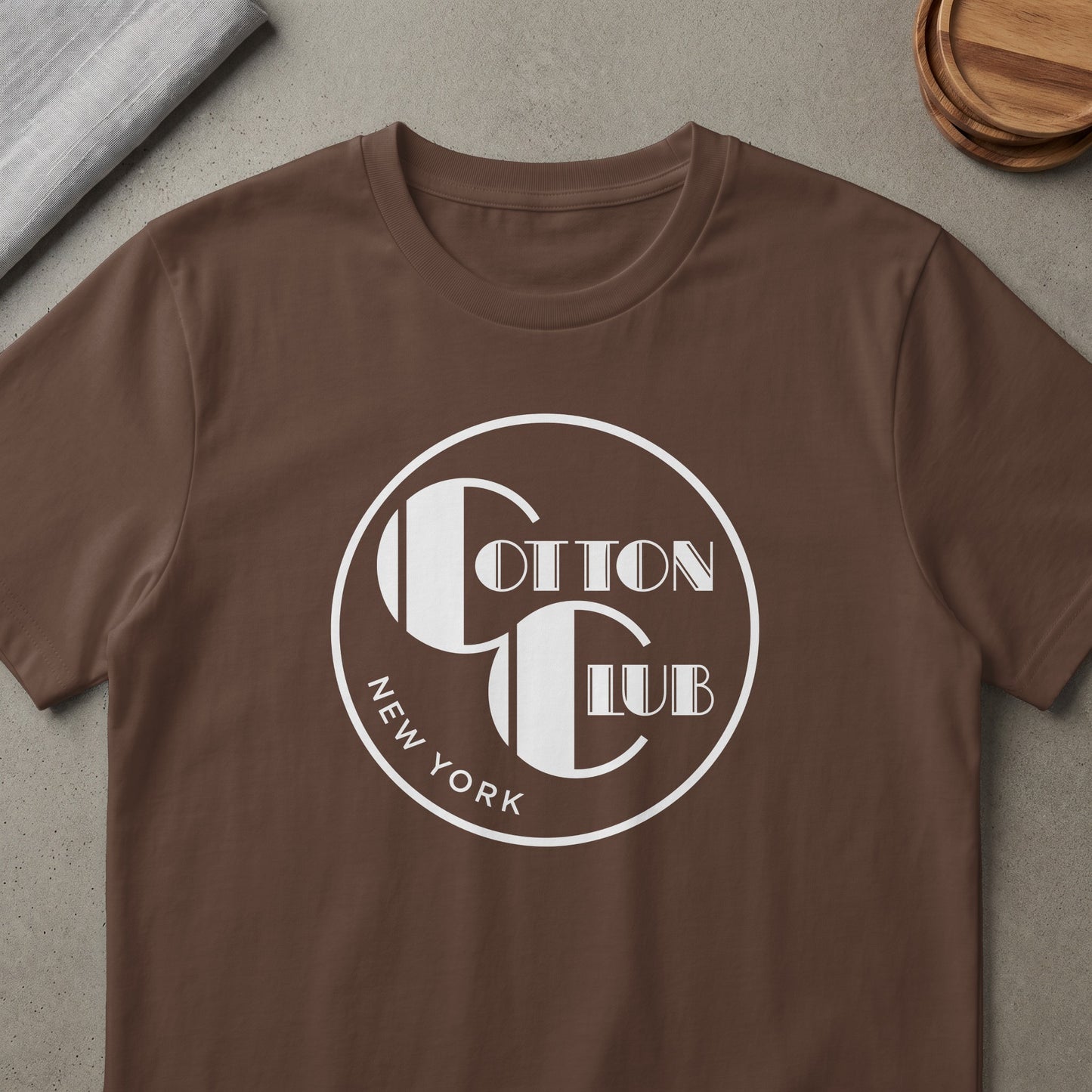 Brown t-shirt with white circular logo for "Cotton Club New York"