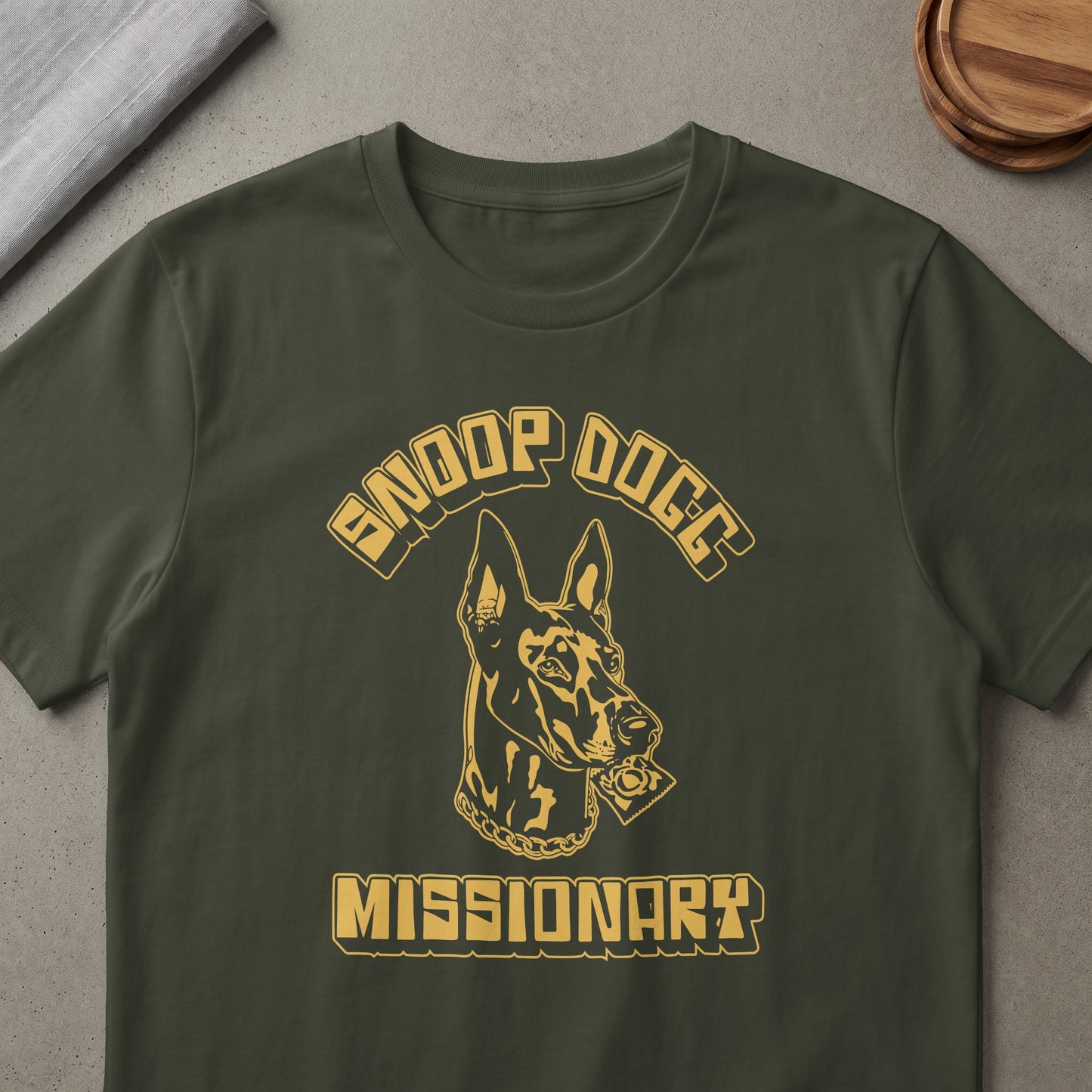 Dark green t-shirt with "Snoop Dogg" and a dog holding a condom above "Missionary" text.