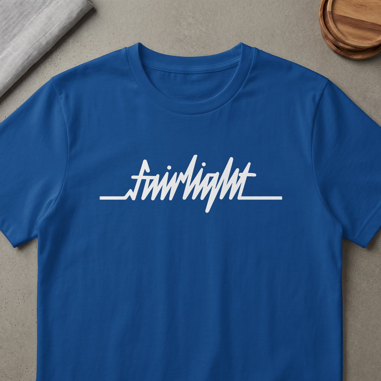 Blue t-shirt with white "fairlight" text and a heart monitor line.