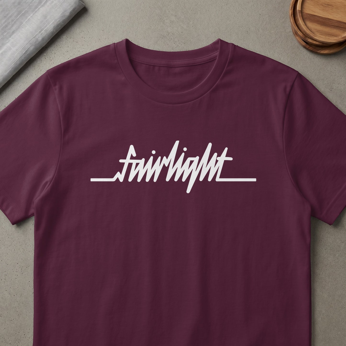 Maroon t-shirt with white "Fairlight" text and wave line graphic.