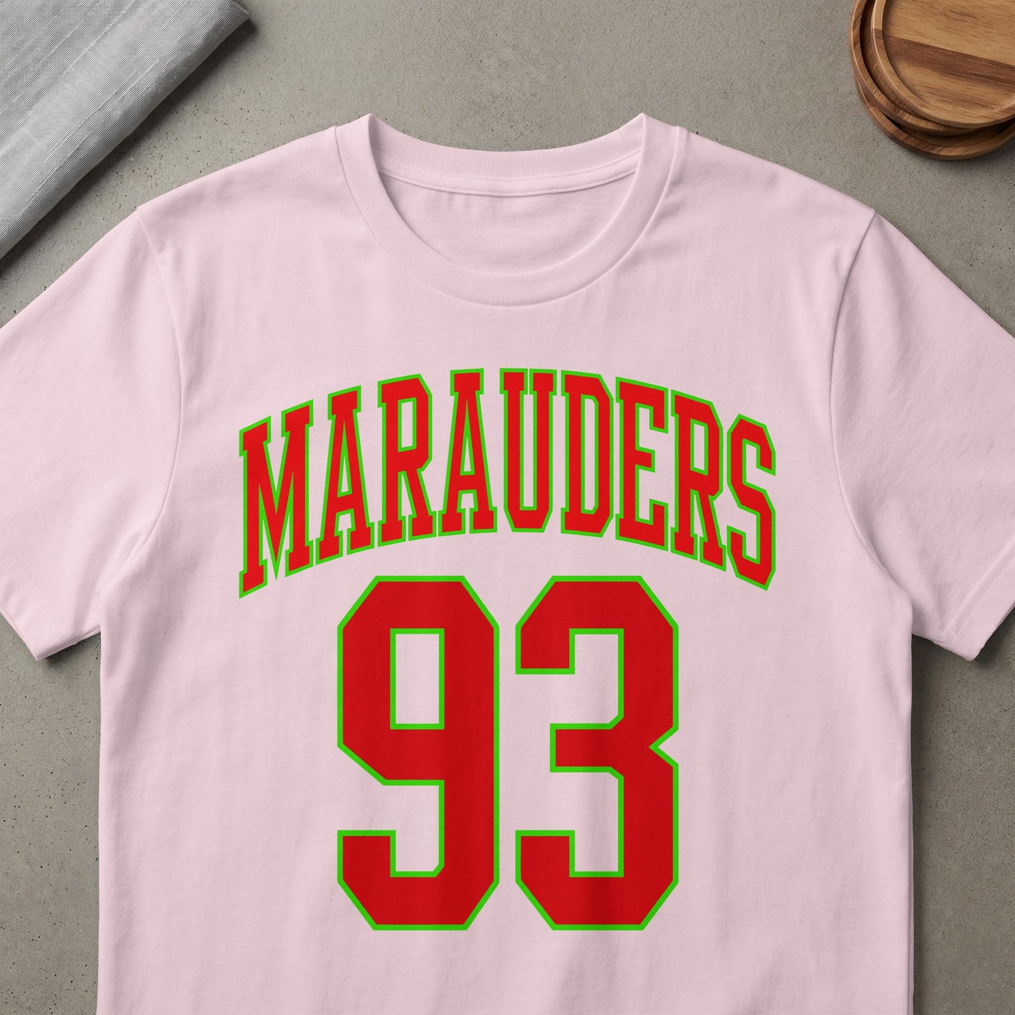 Pink t-shirt with red and green "Marauders 93" text.