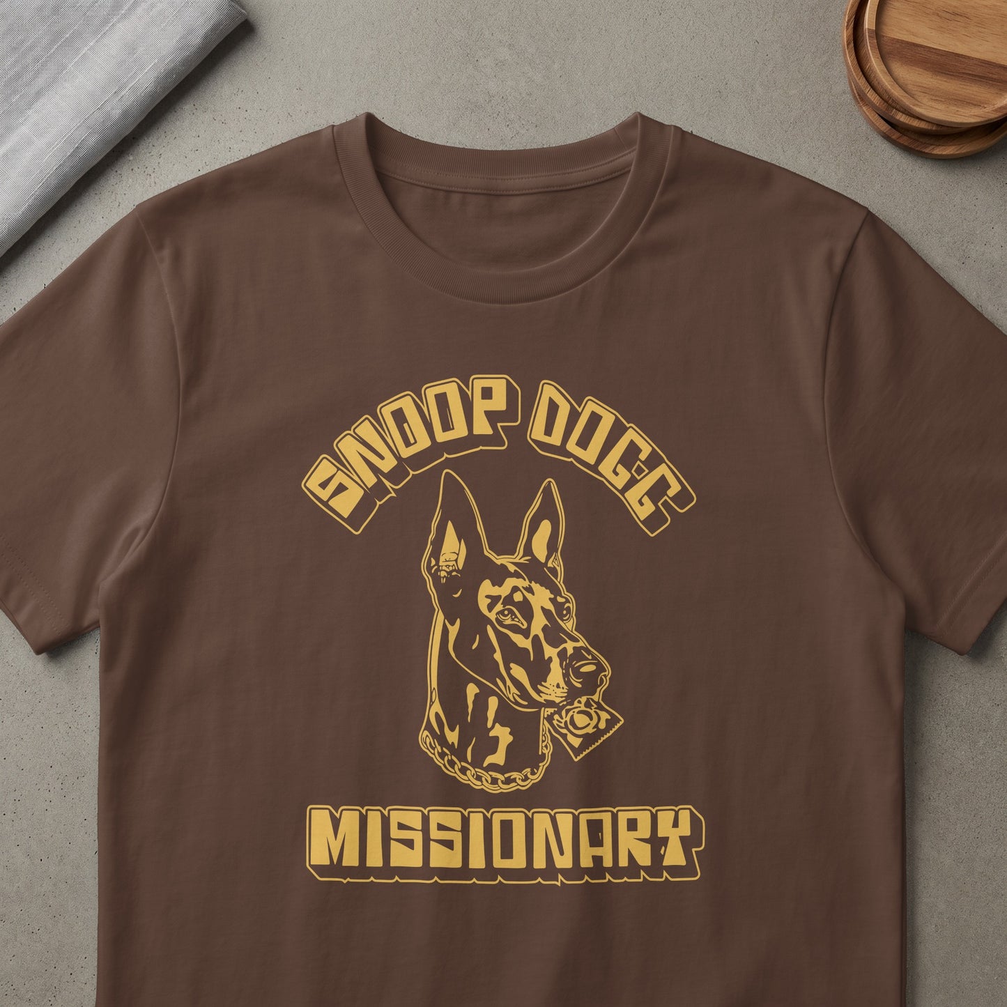 Brown t-shirt with gold Snoop Dogg Missionary graphic featuring a dog wearing a chain.
