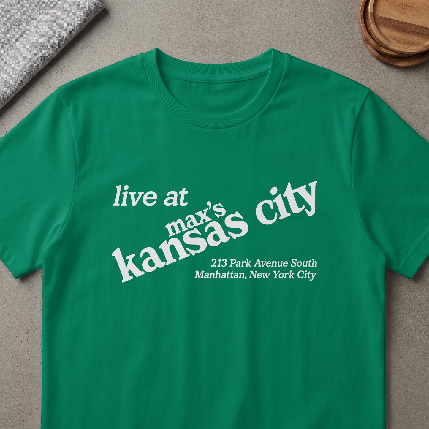 Green t-shirt with white text: "live at max's kansas city 213 Park Avenue South Manhattan, New York City"