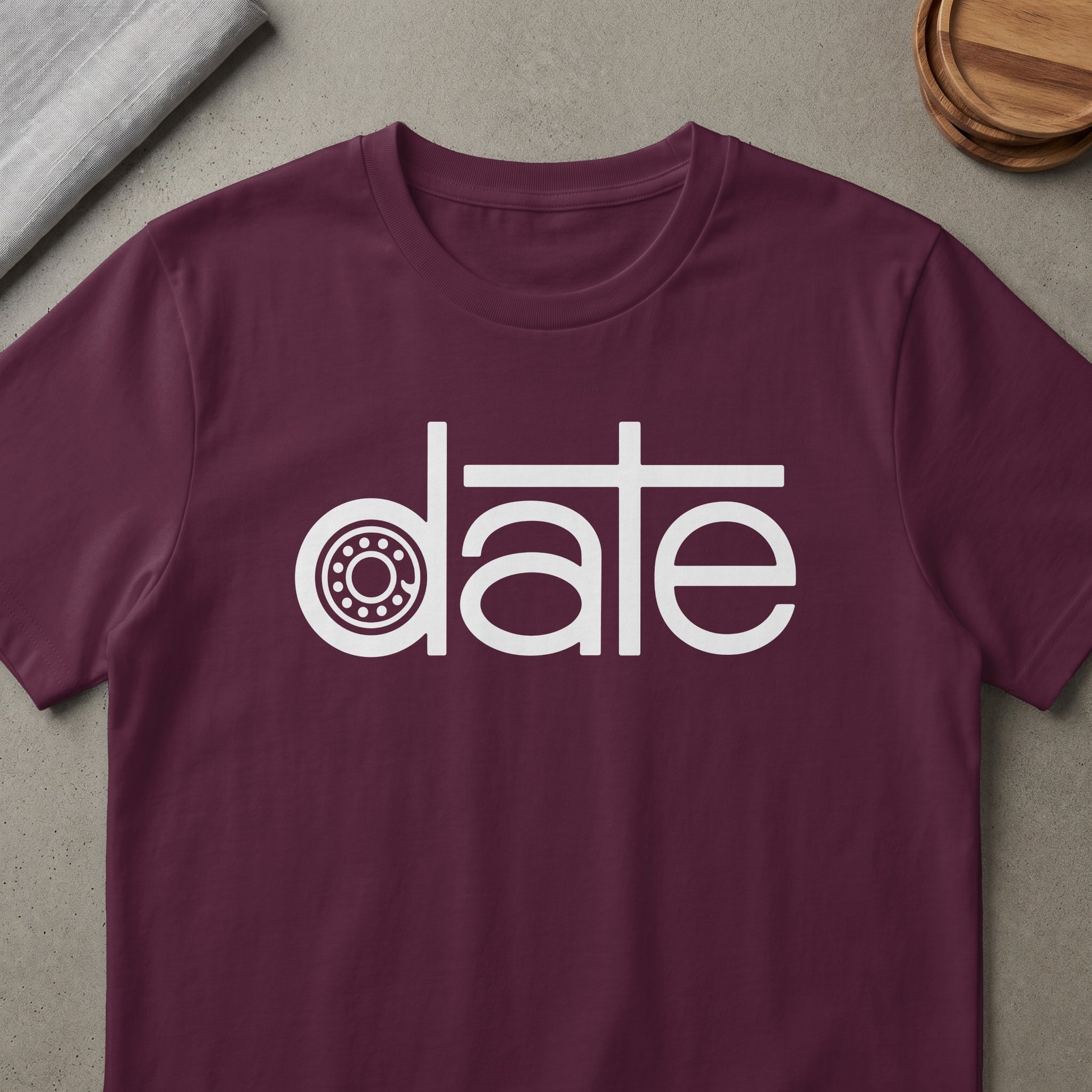 Maroon t-shirt with white graphic text that says "date" with a wheel graphic.