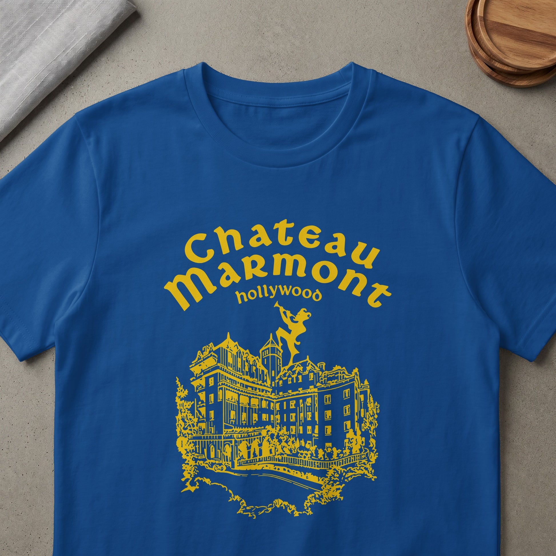 Blue t-shirt with yellow Chateau Marmont Hollywood logo and building illustration.