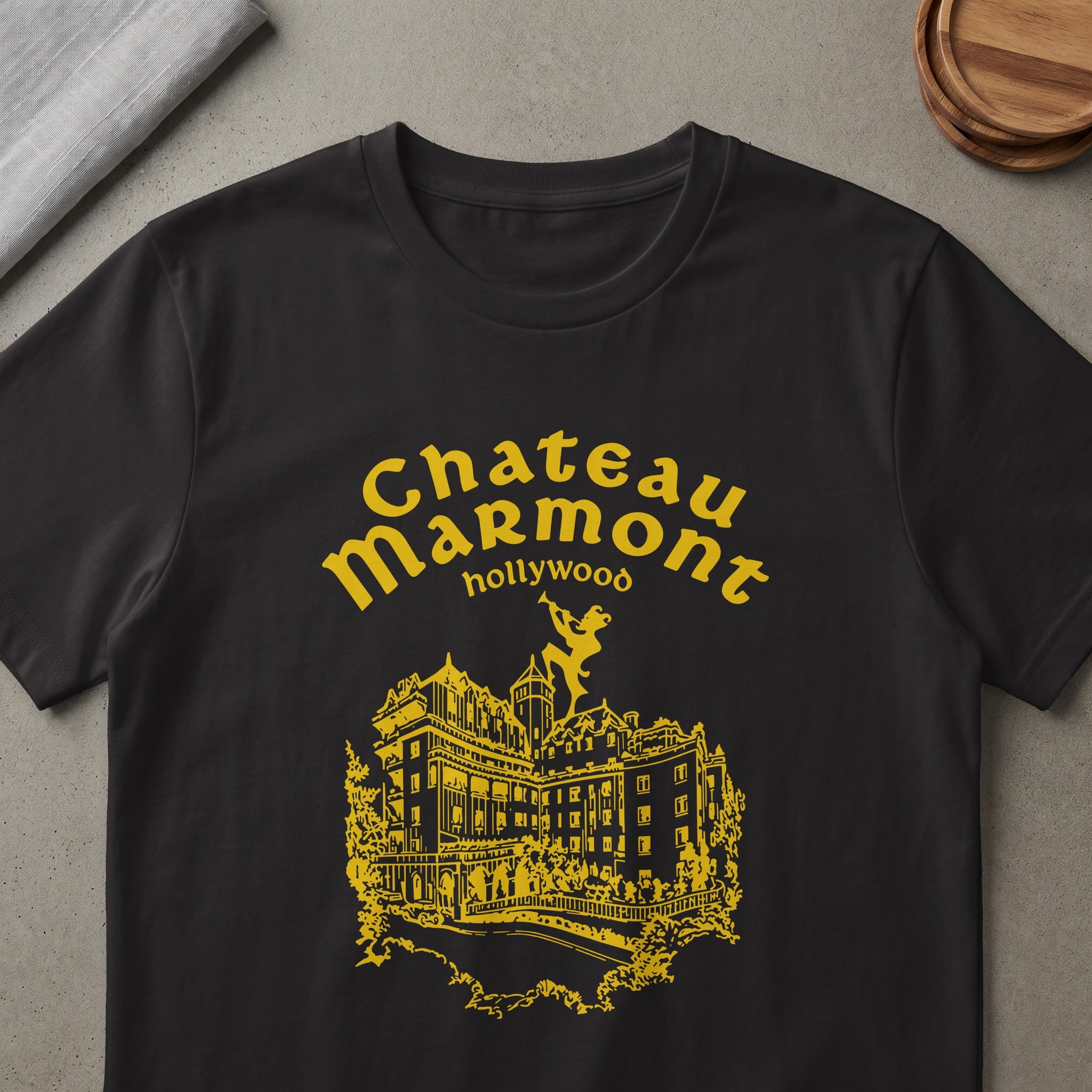 Black t-shirt with yellow Chateau Marmont Hollywood graphic and building illustration.