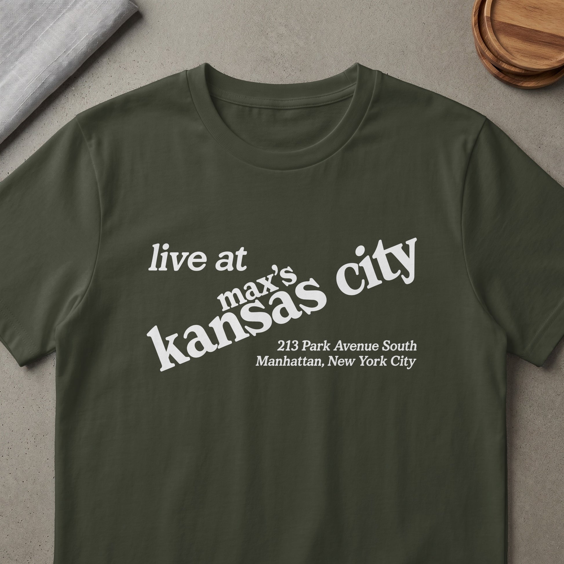 Dark green t-shirt with white text: "live at max's kansas city, 213 Park Avenue South Manhattan, New York City".