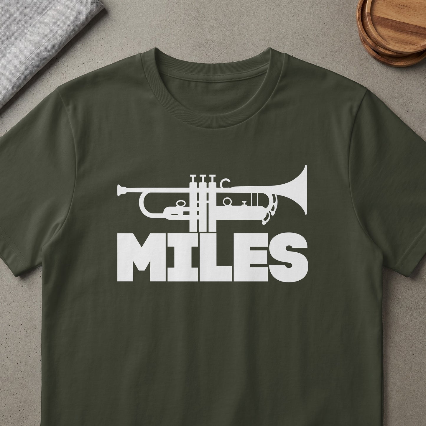 Dark green t-shirt with white trumpet graphic and "MILES" text.