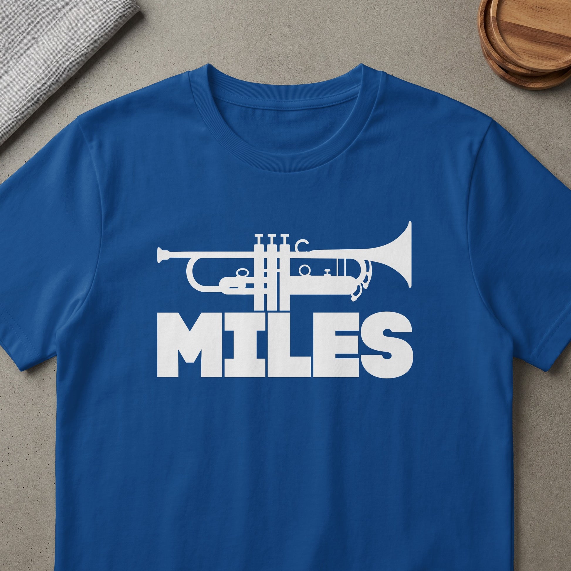 Blue t-shirt with white trumpet graphic and the word "MILES"