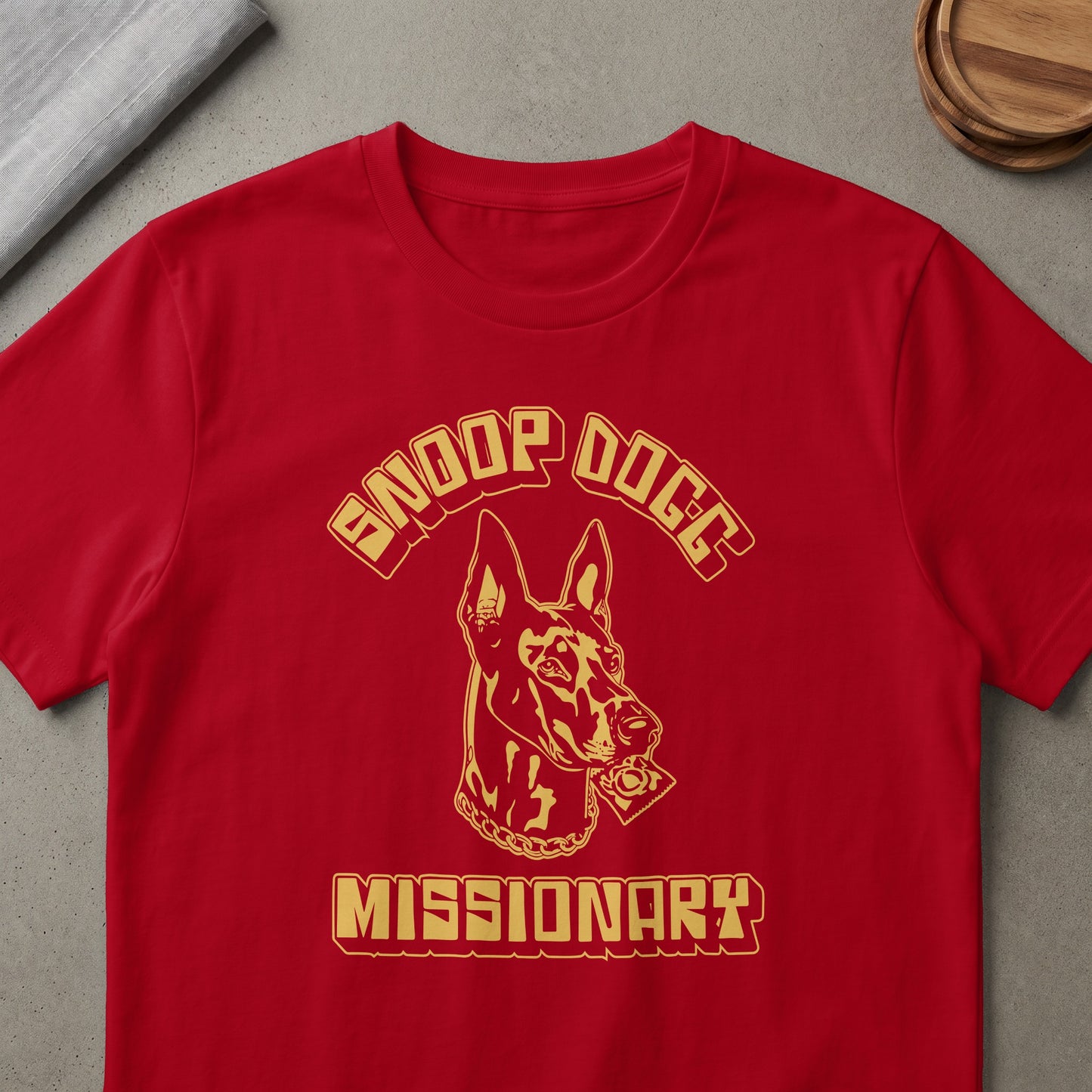 Red t-shirt with gold Snoop Dogg text, dog head, and Missionary text.